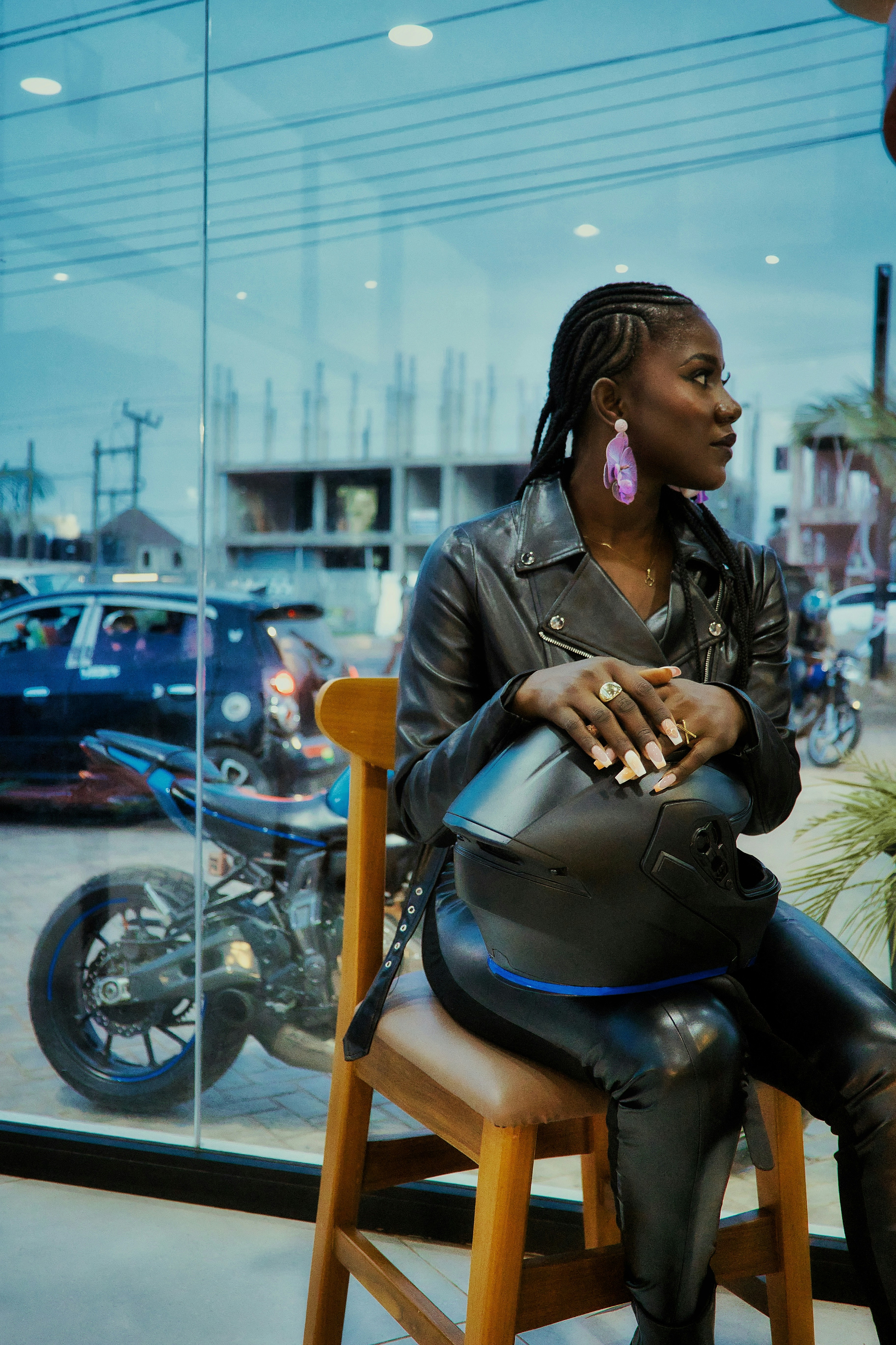 Woman in leather jacket holding motorcycle helmet