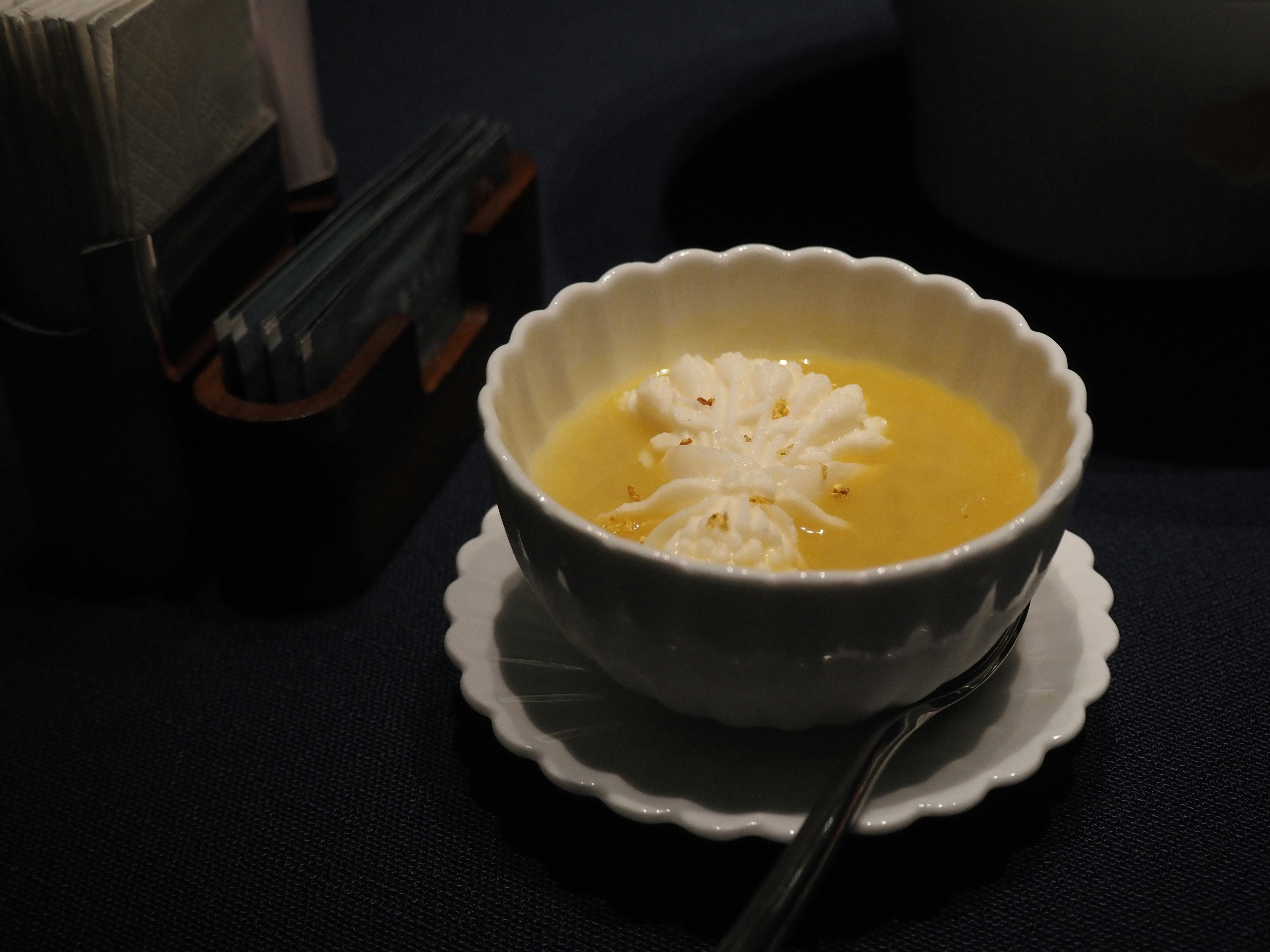 Un bol de soupe jaune crémeuse avec garniture à la crème fouettée