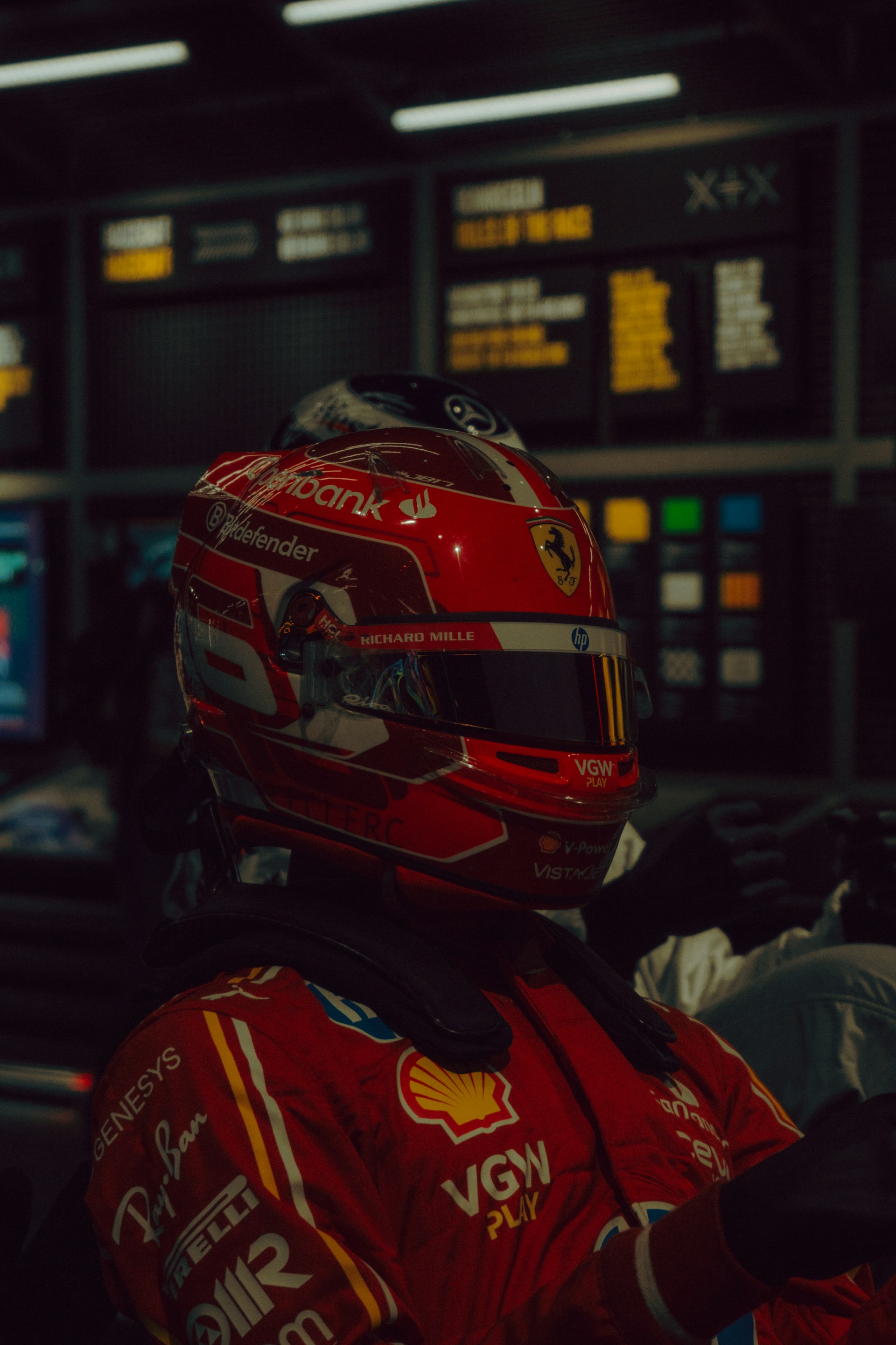 Formula 1 driver in red racing suit and helmet.