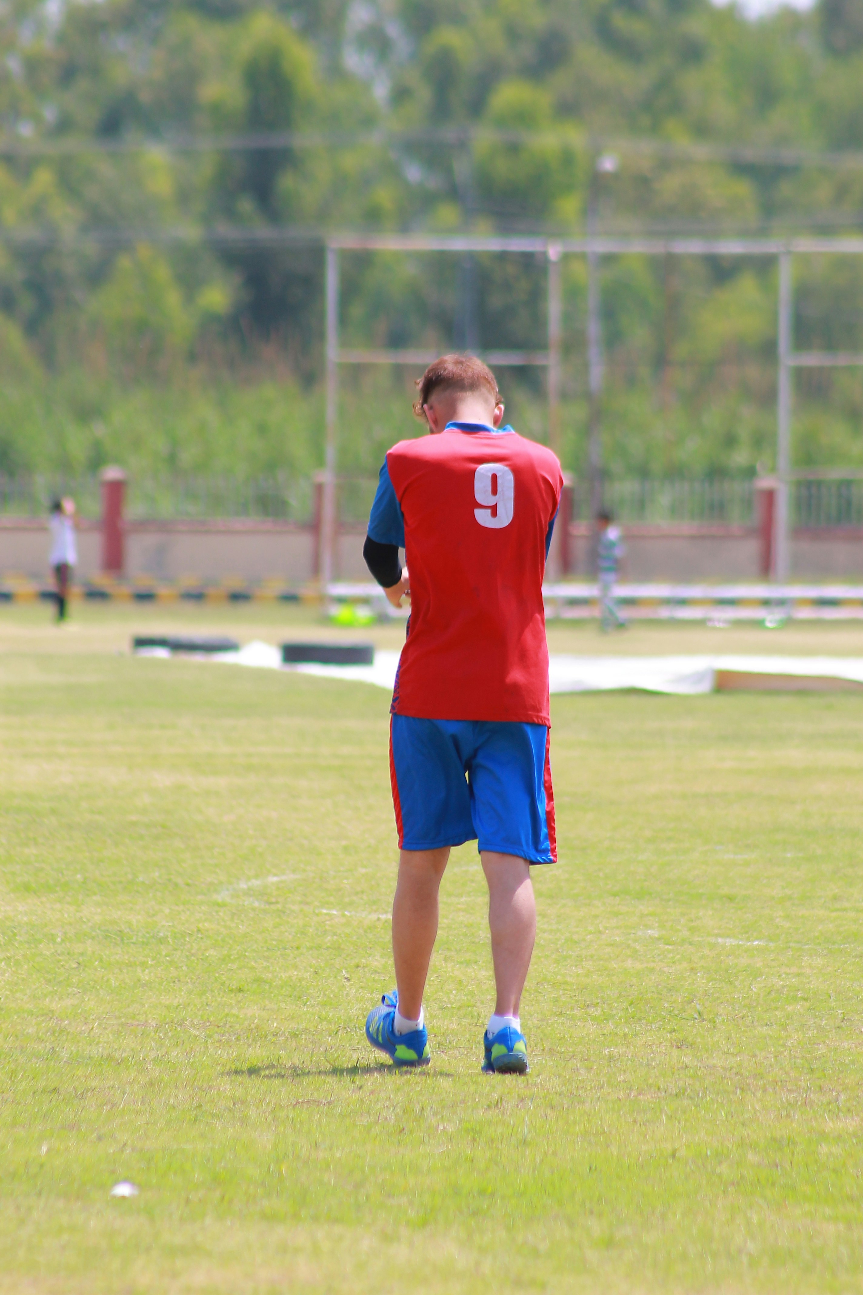 Man in red jersey with number nine on field