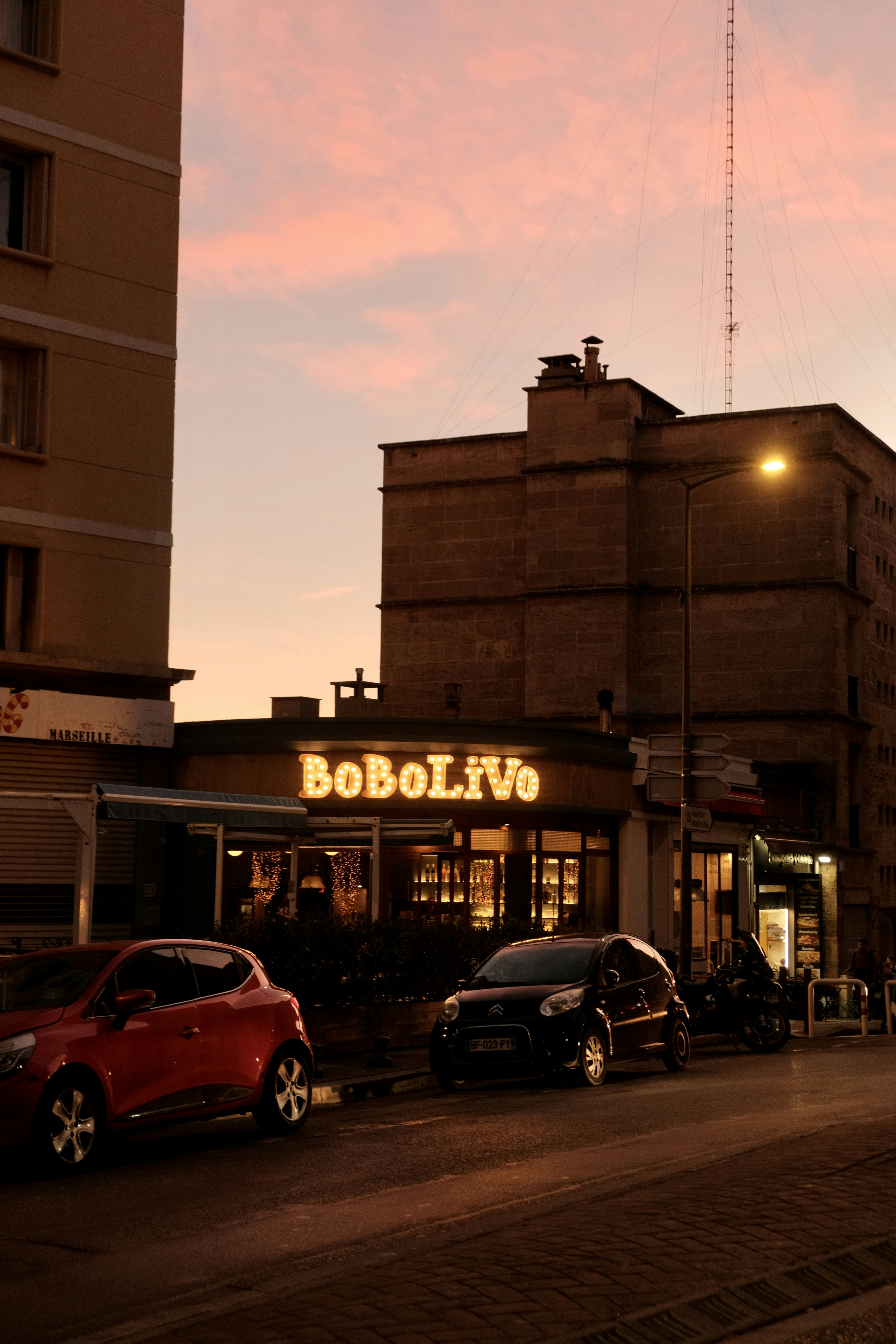 Street scene with buildings and cars at sunset