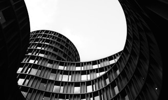 Curved modern building with many windows against sky