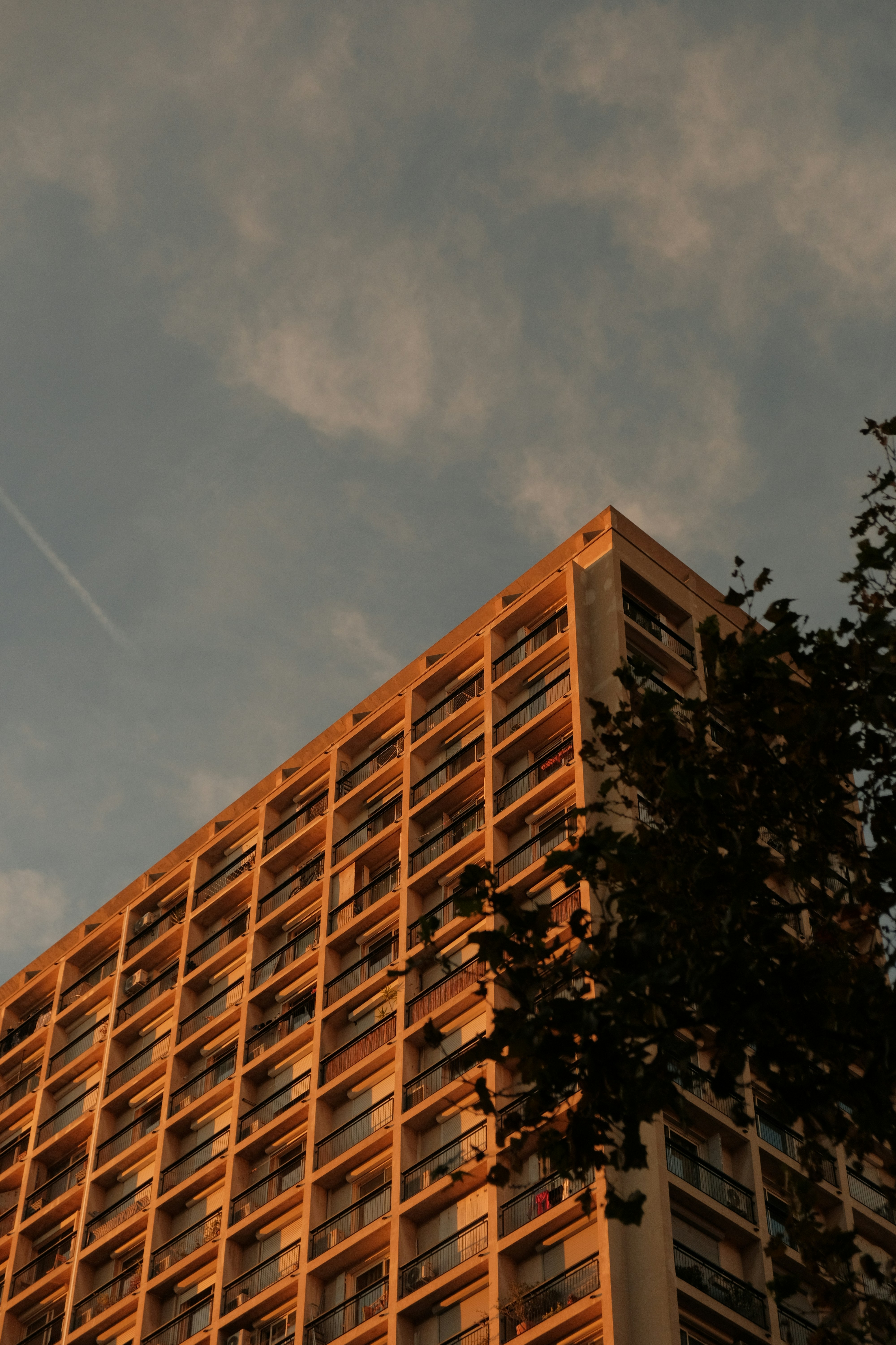 Modern apartment building facade bathed in golden hour light.