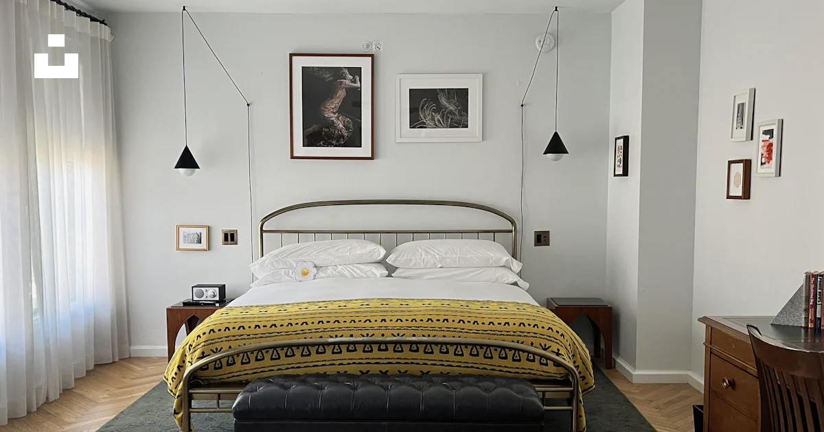A stylish bedroom with a metal bed and artwork. photo – Free Interior ...
