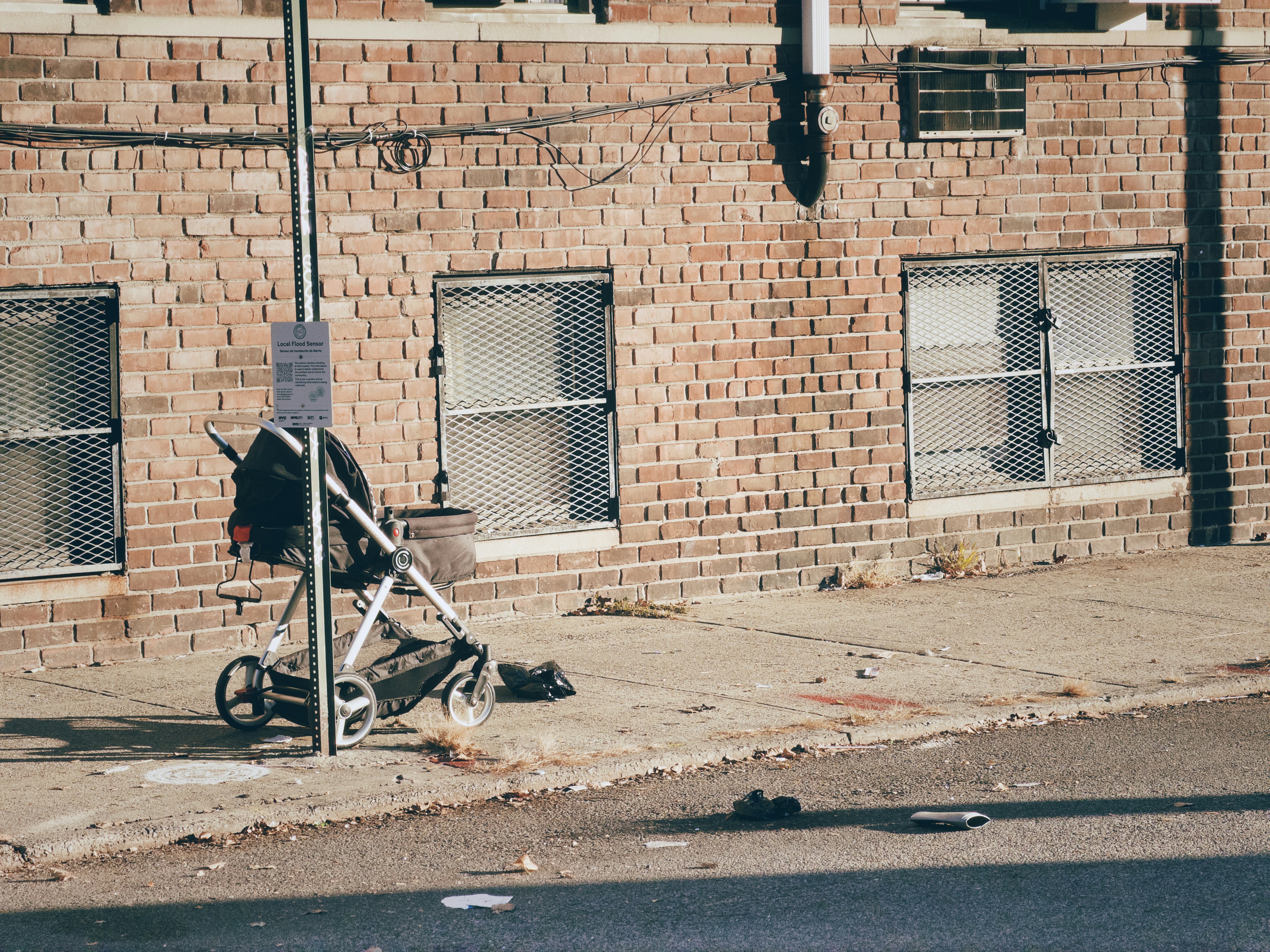 Stroller and debris on a sidewalk.