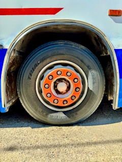 Close-up of a bus wheel with orange lug nuts.