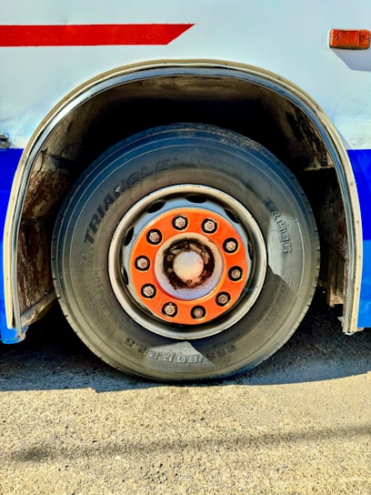 Close-up of a bus wheel with orange lug nuts.