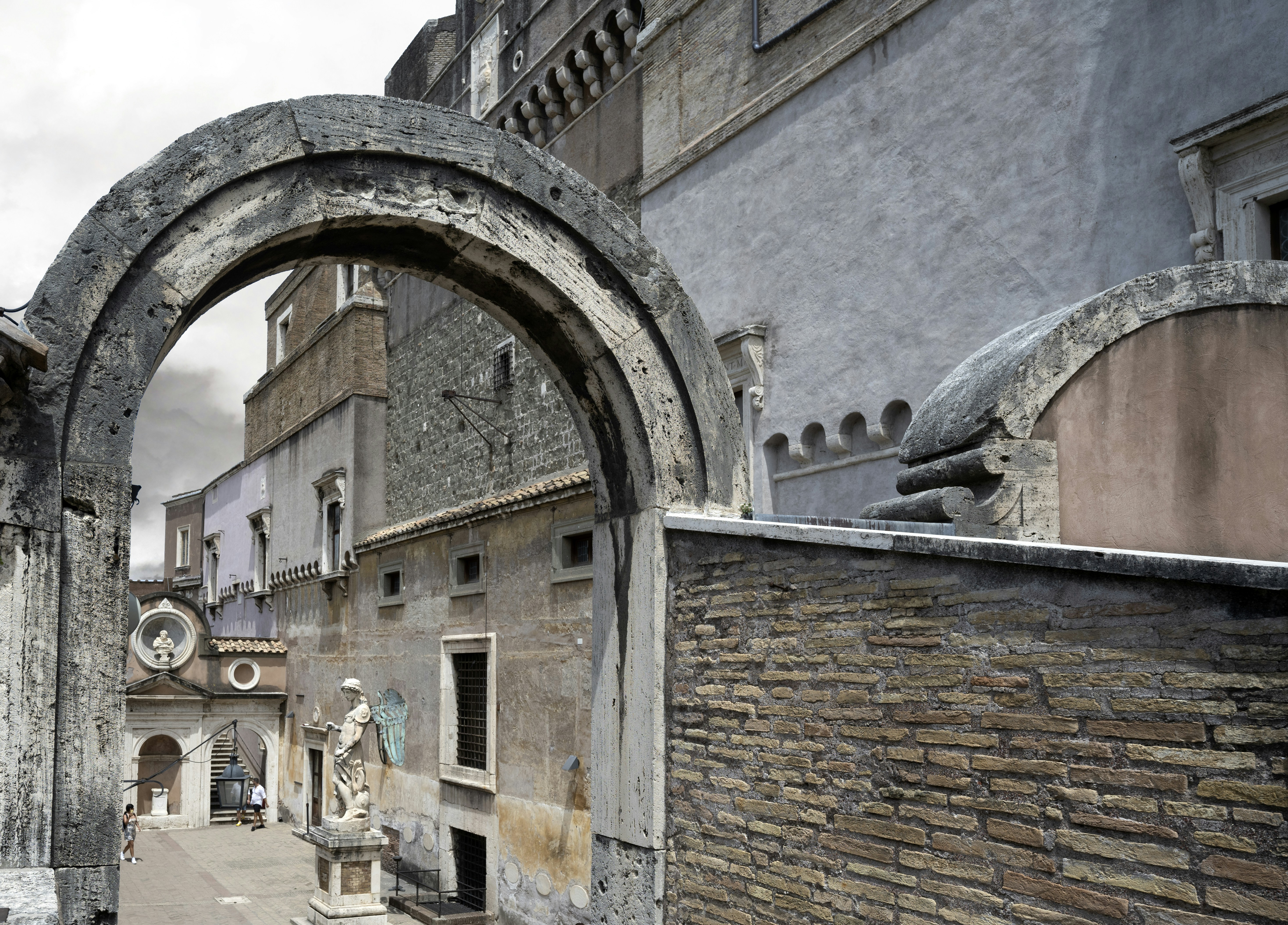 La cour de l'Ange du château Saint-Ange, son arche de pierre et la statue de marbre de l'archange au fond.