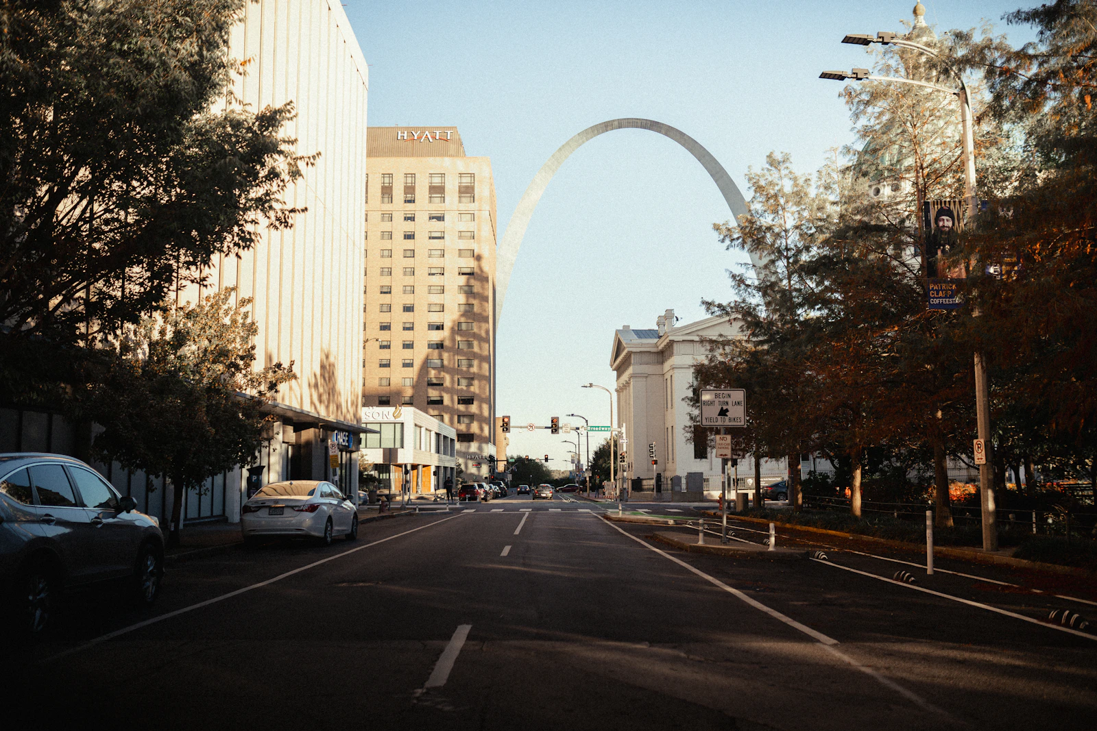 Market Street in downtown St. Louis at golden hour, looking east toward the Gateway Arch and the Old Courthouse