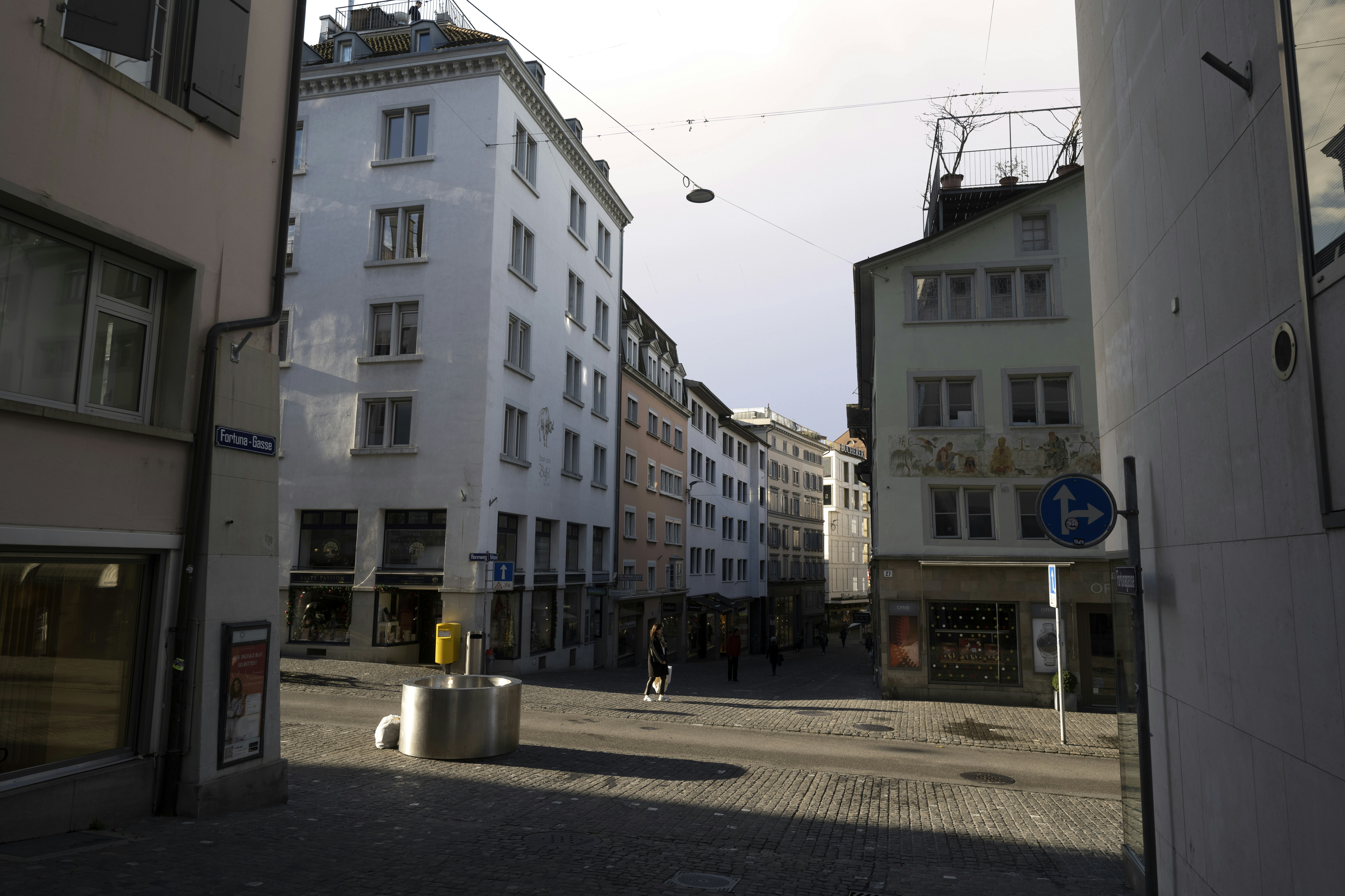 Buildings line a european street with a clear sky.