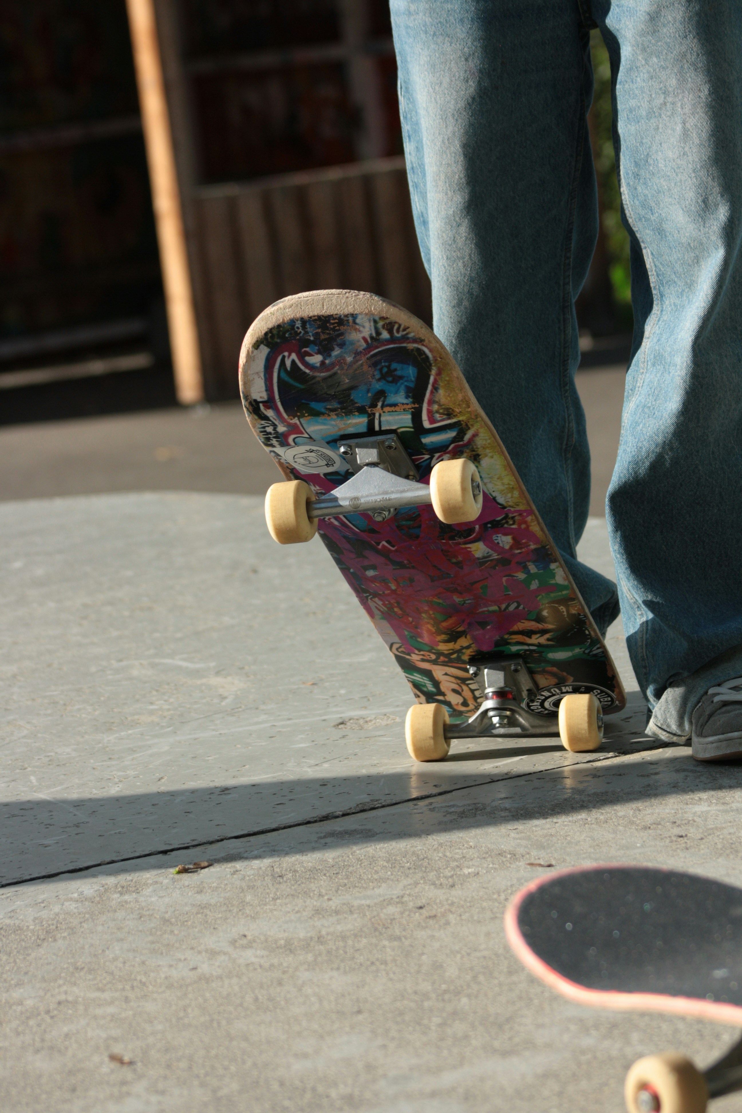 Person standing with a skateboard on concrete