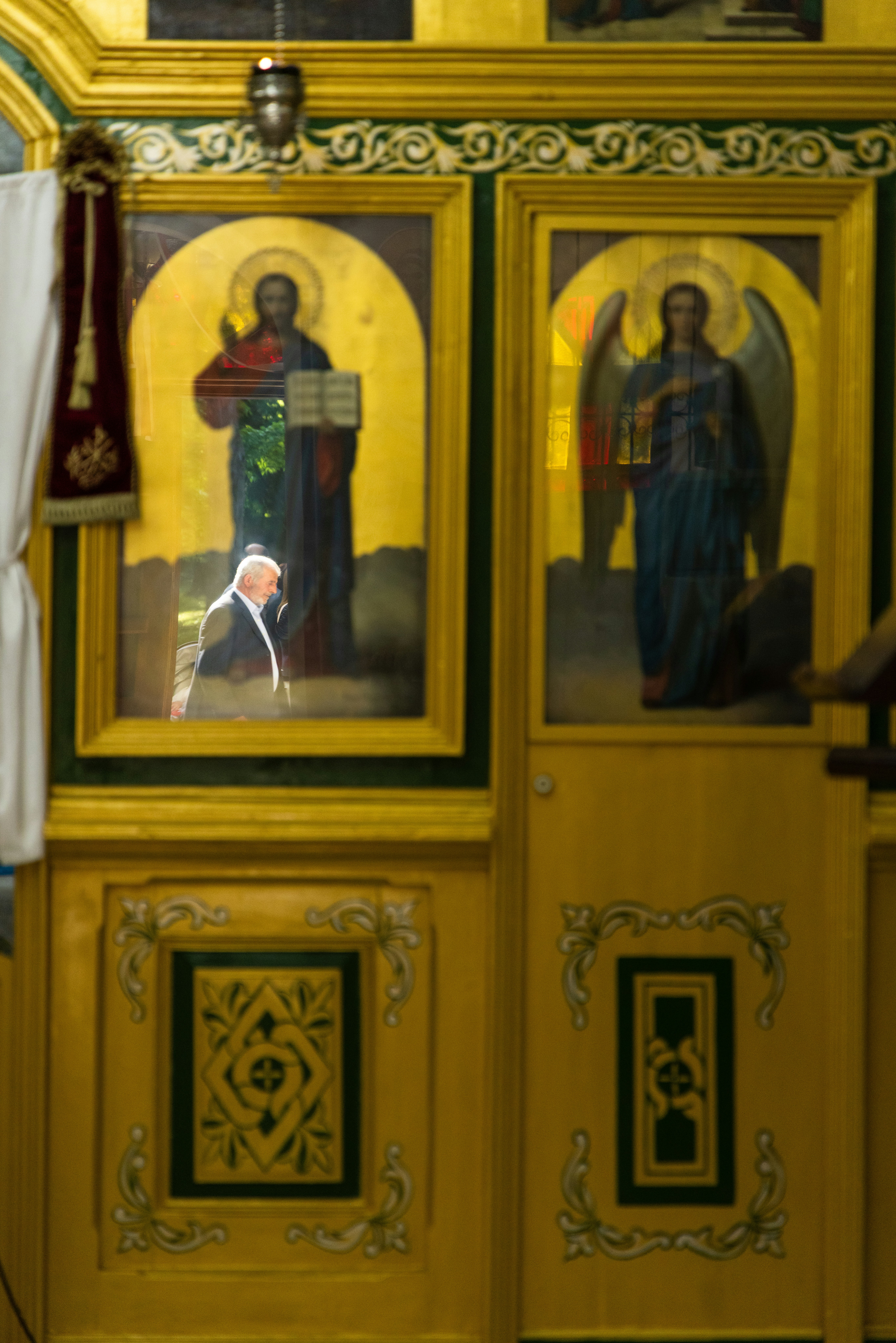 Hombre de traje reflejado en iconos religiosos