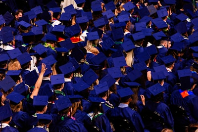 Graduation ceremony with students in blue caps and gowns.