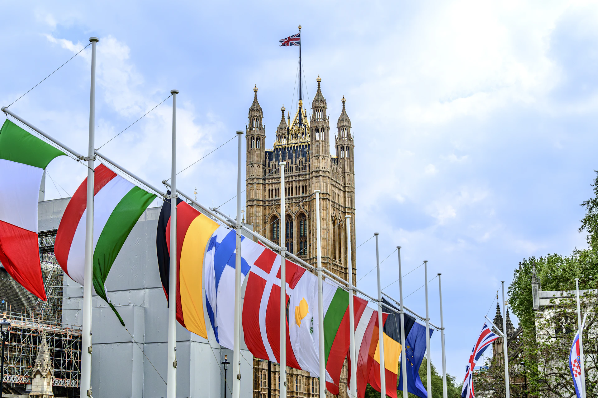 Flags of various countries in front of a building.