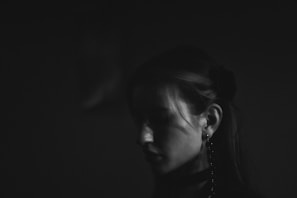 Woman's profile in dramatic black and white lighting.
