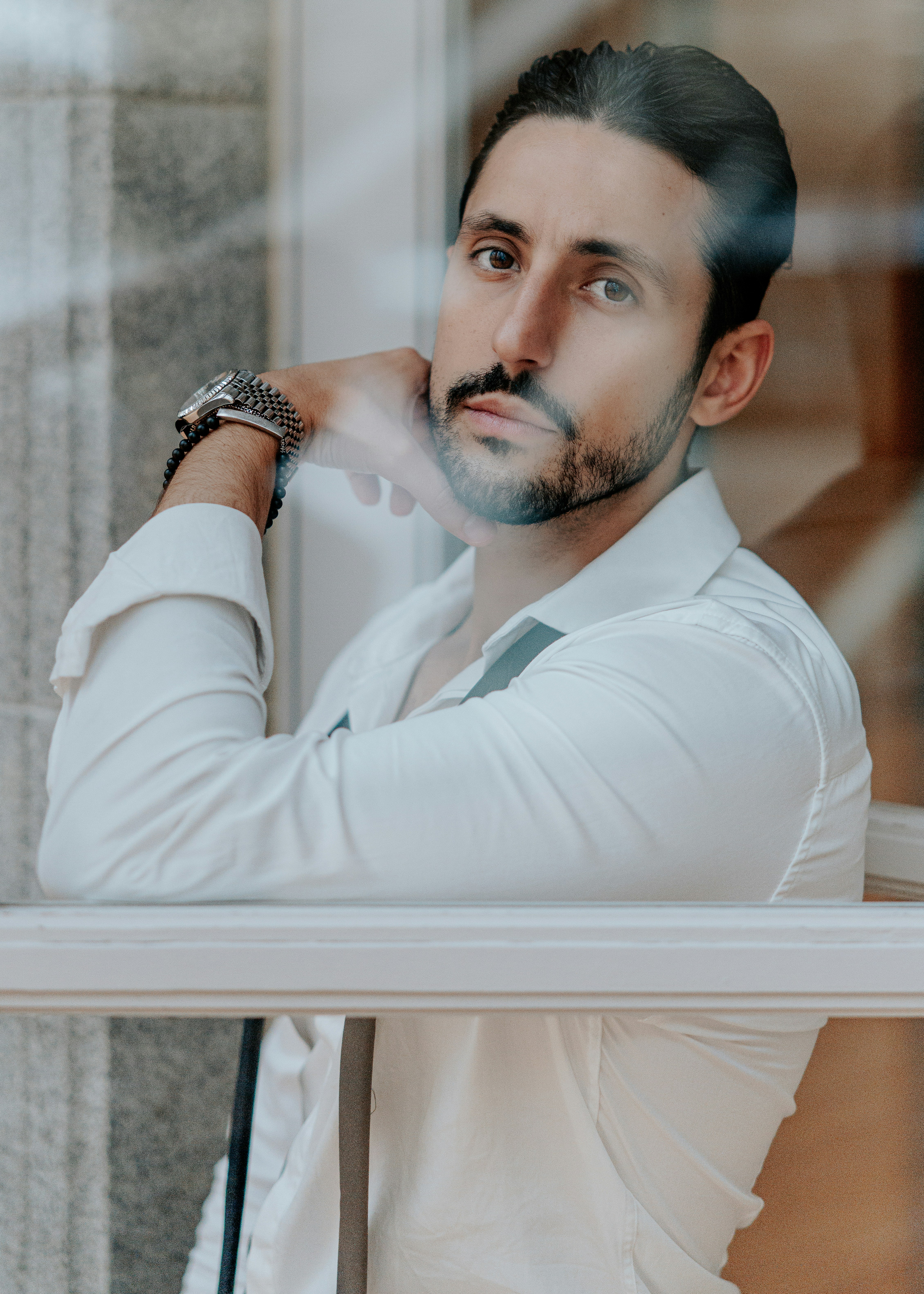 Man in white shirt looking thoughtfully out window