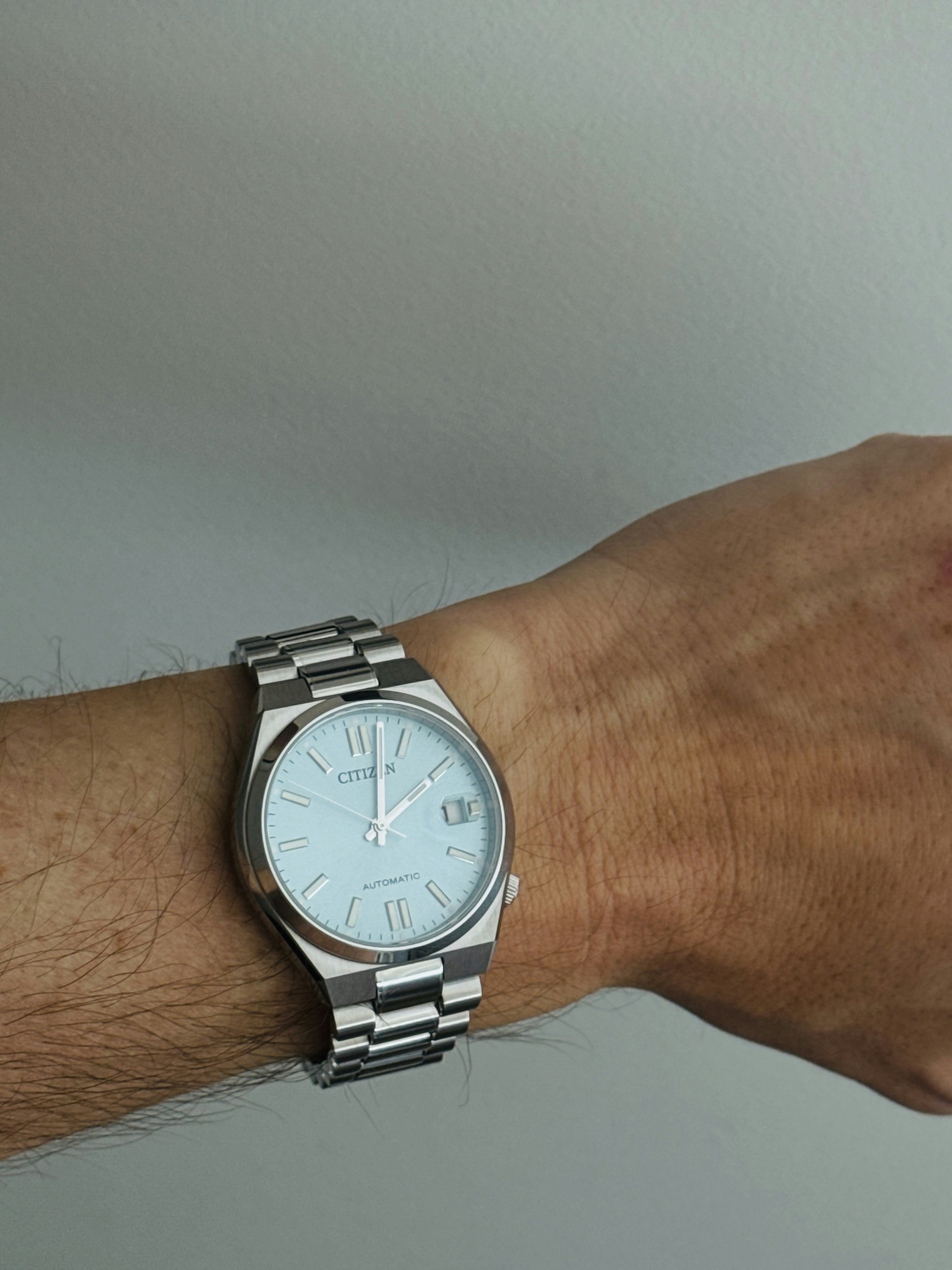 Man wearing a silver wristwatch on his arm.