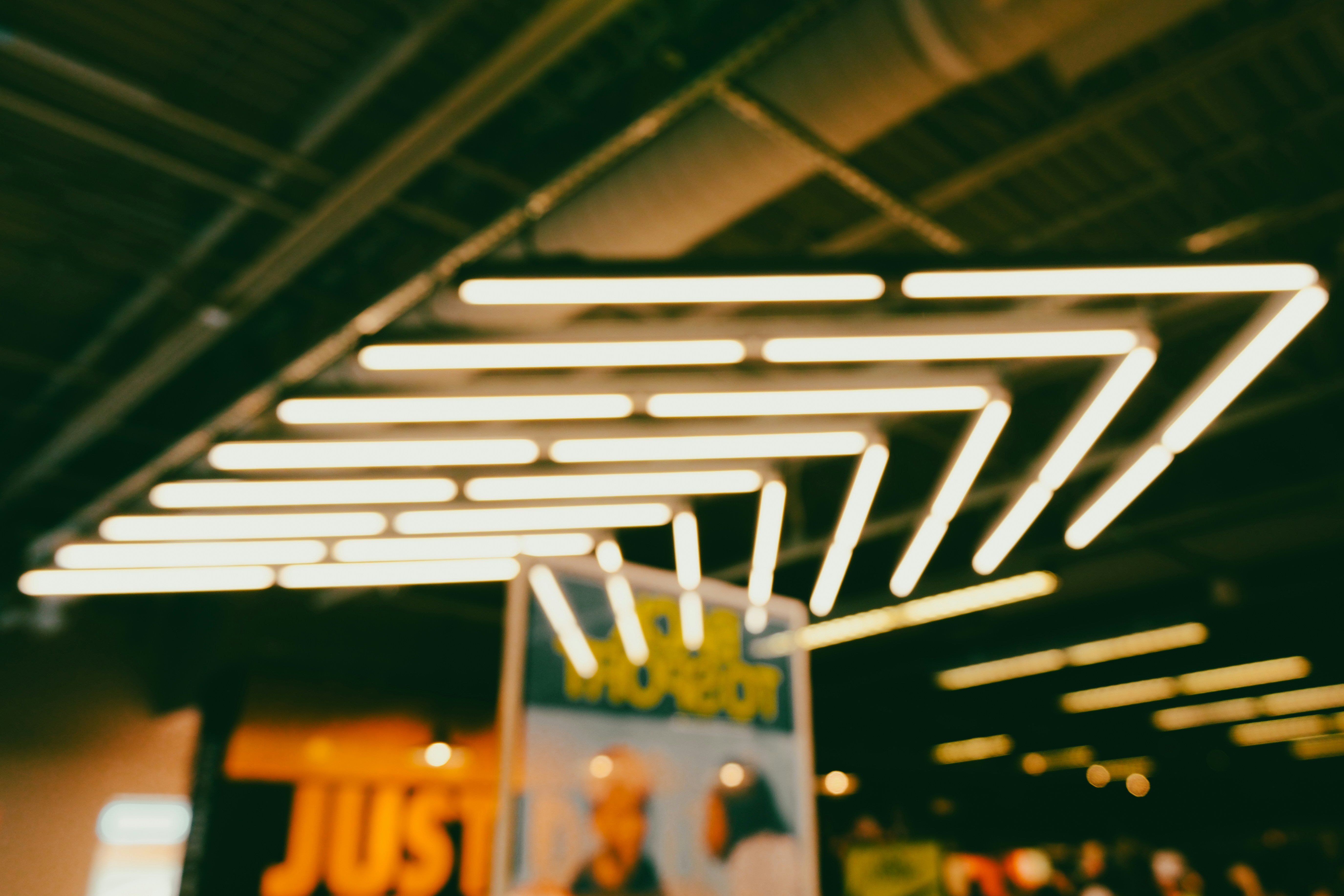 Geometric light fixture with fluorescent tubes indoors.