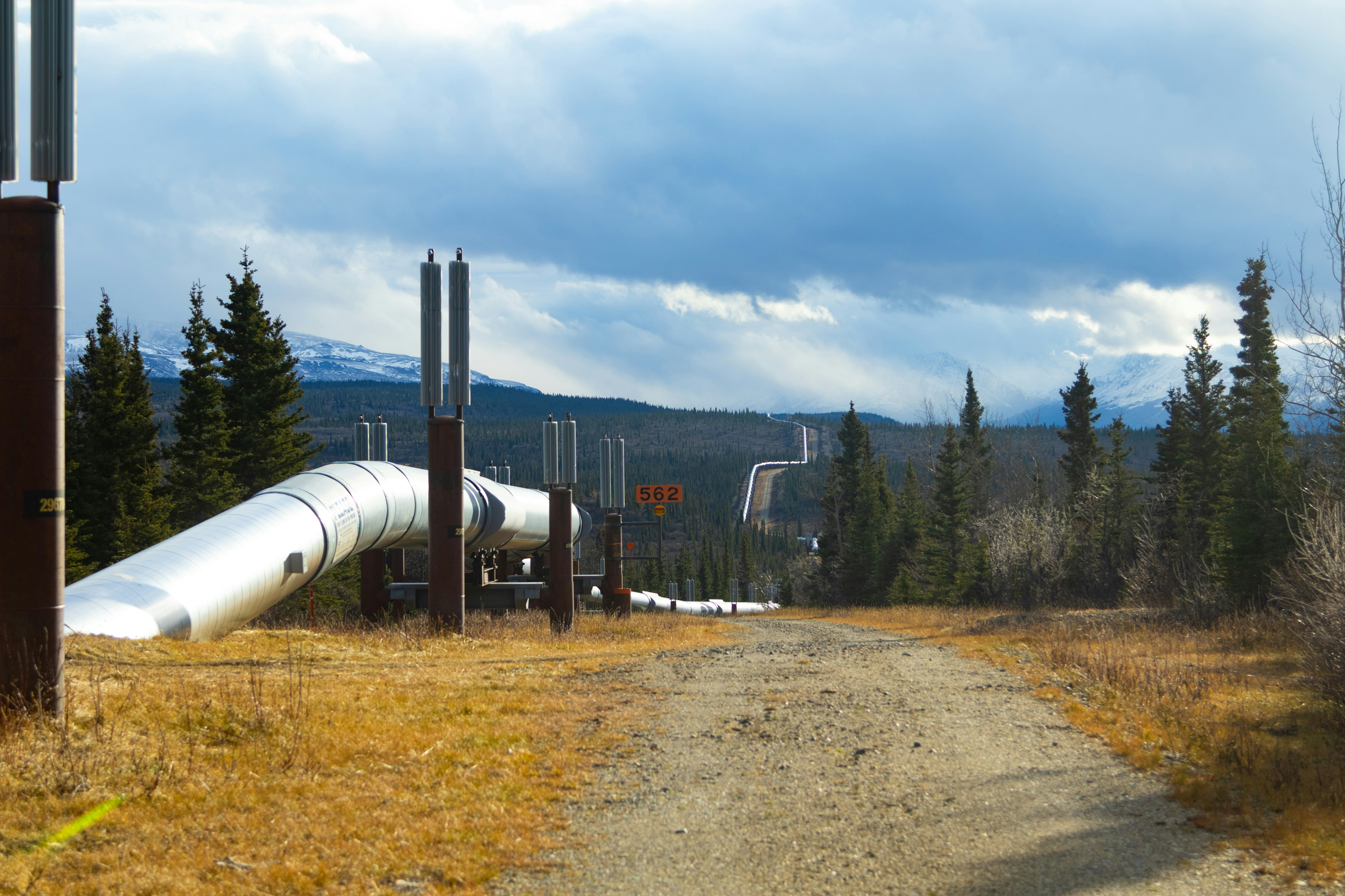 Large pipeline runs through a wooded, mountainous landscape