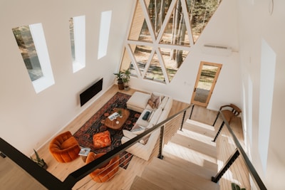 Modern a-frame cabin living room with large geometric window.