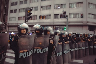Police officers in riot gear stand in formation.