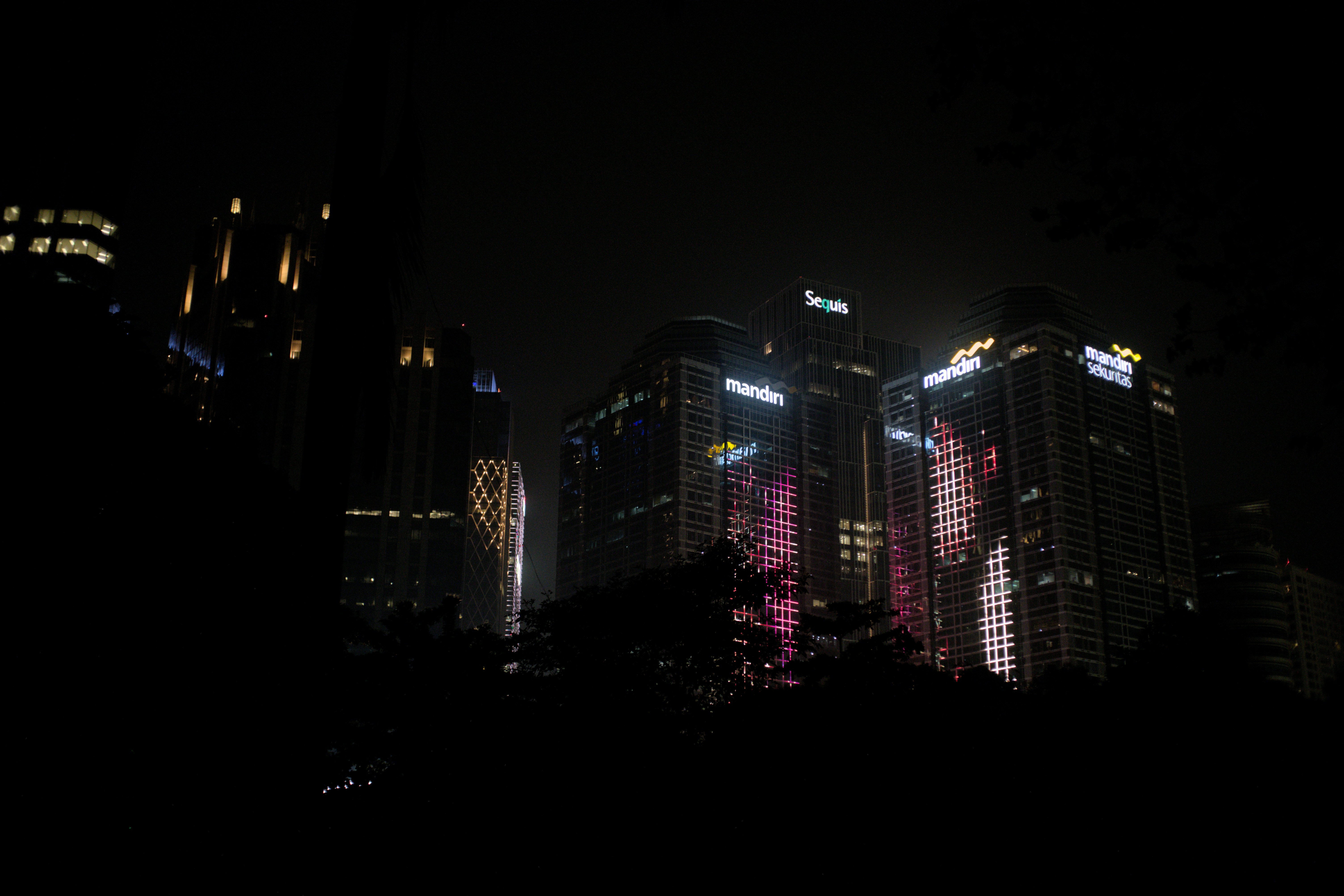 City skyline with illuminated skyscrapers at night.