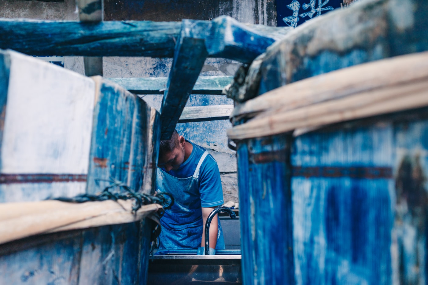 A worker dyeing fabric in an indigo workshop