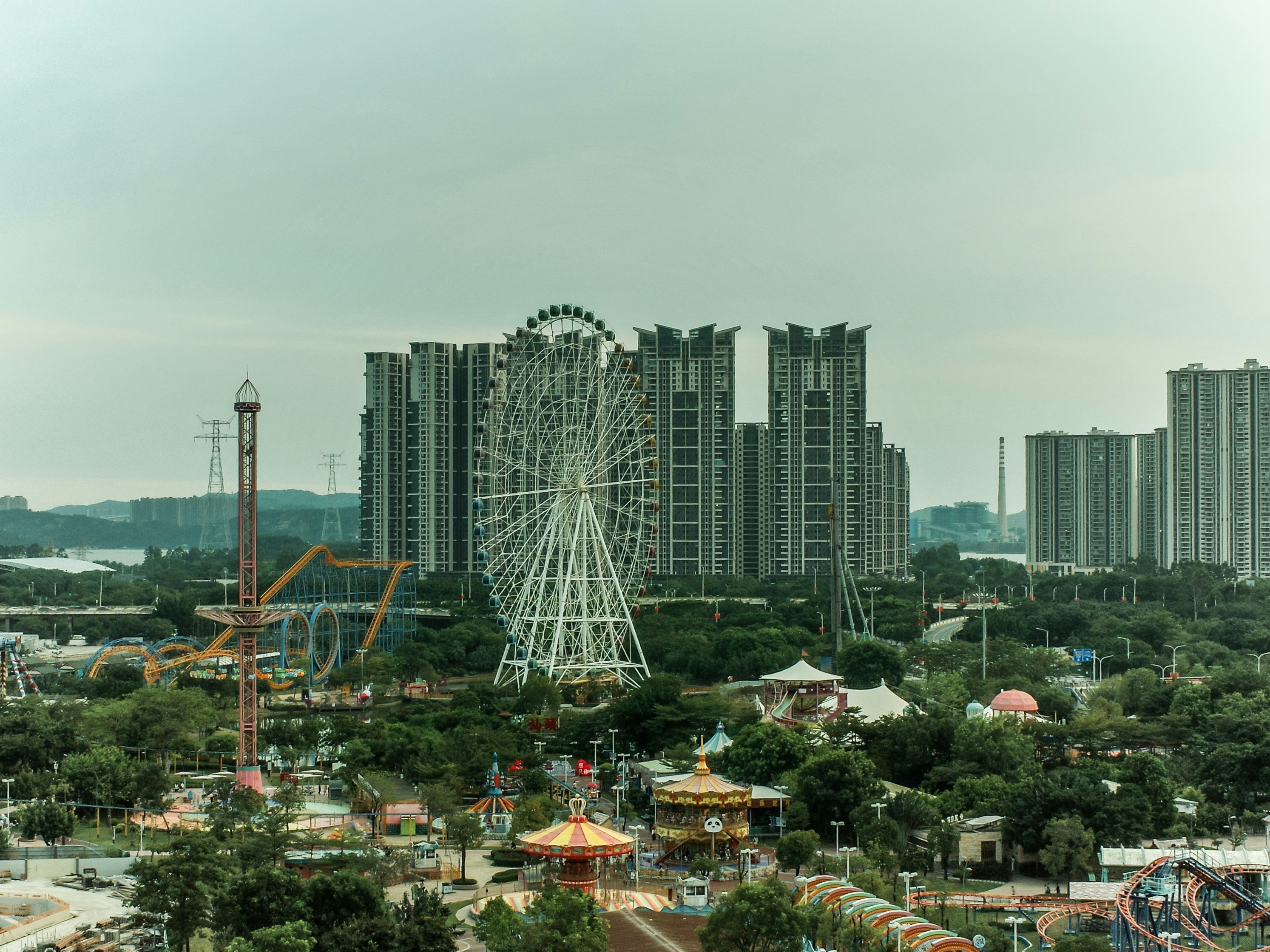 Amusement park with ferris wheel and tall buildings.