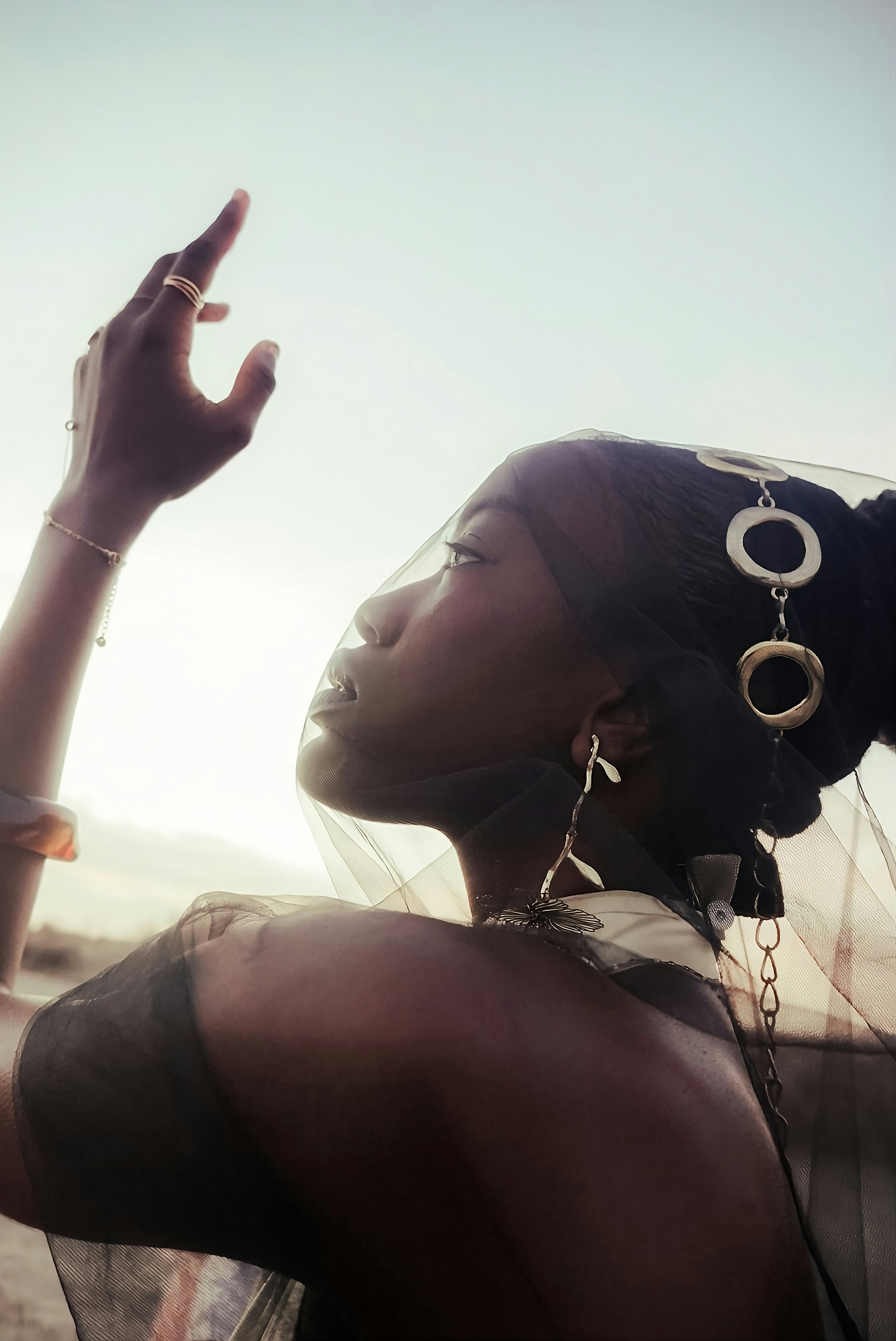 Une femme voilée avec des bijoux ornés tend la main.