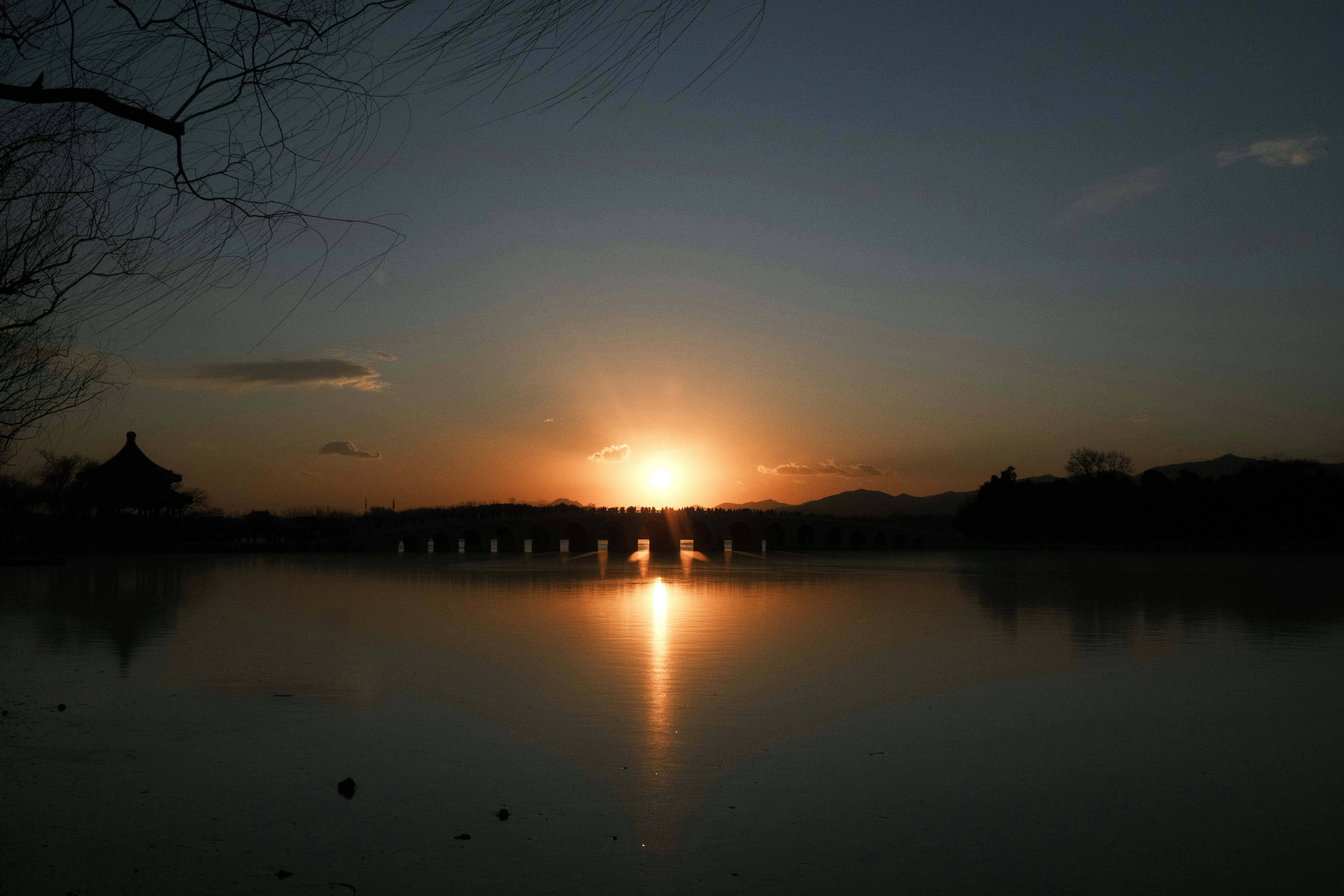 Atardecer sobre un puente y aguas tranquilas
