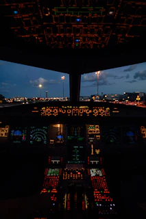 Airplane cockpit at dusk with illuminated controls