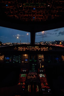 Airplane cockpit at dusk with illuminated controls