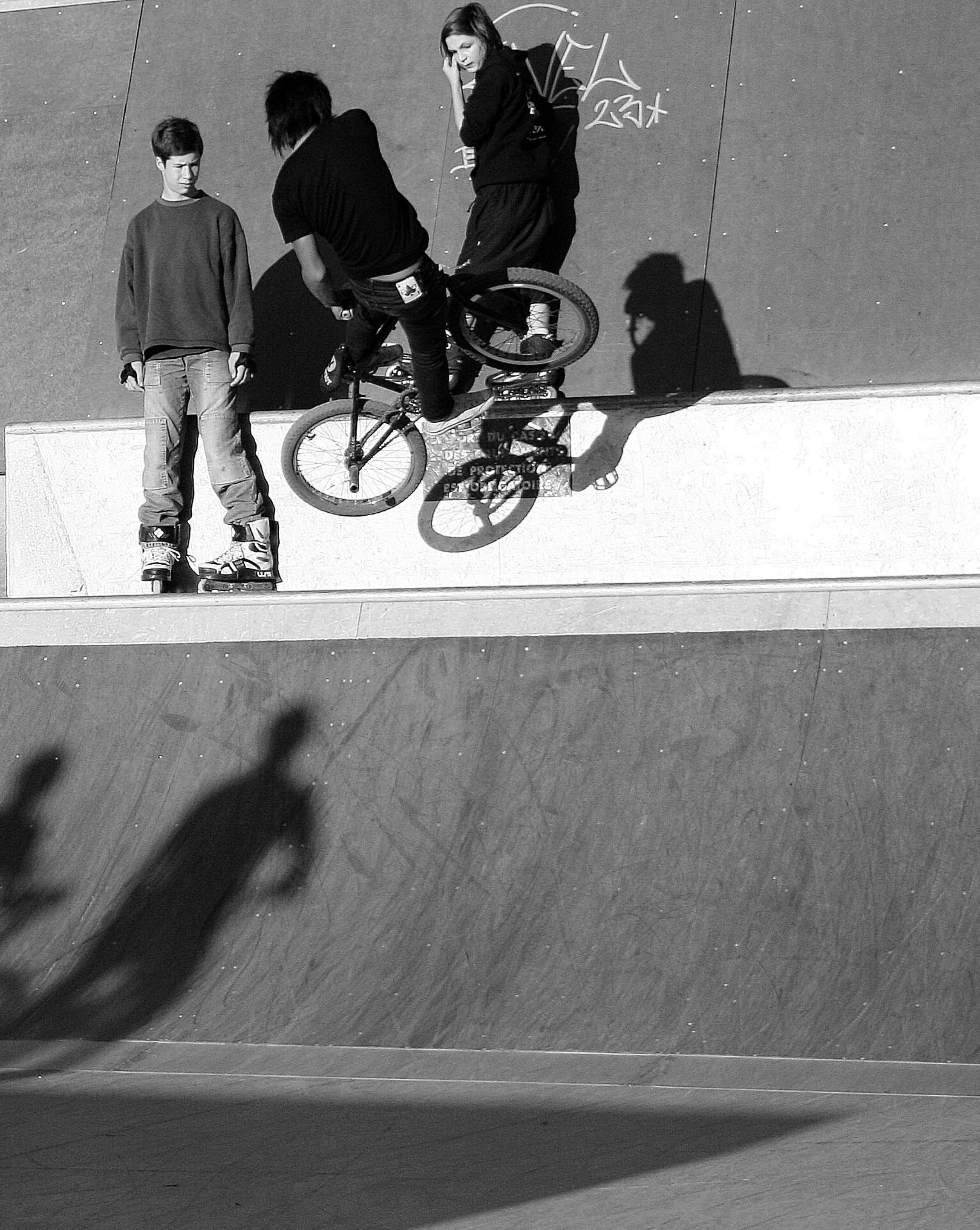 Teens skateboarding and biking in a skatepark