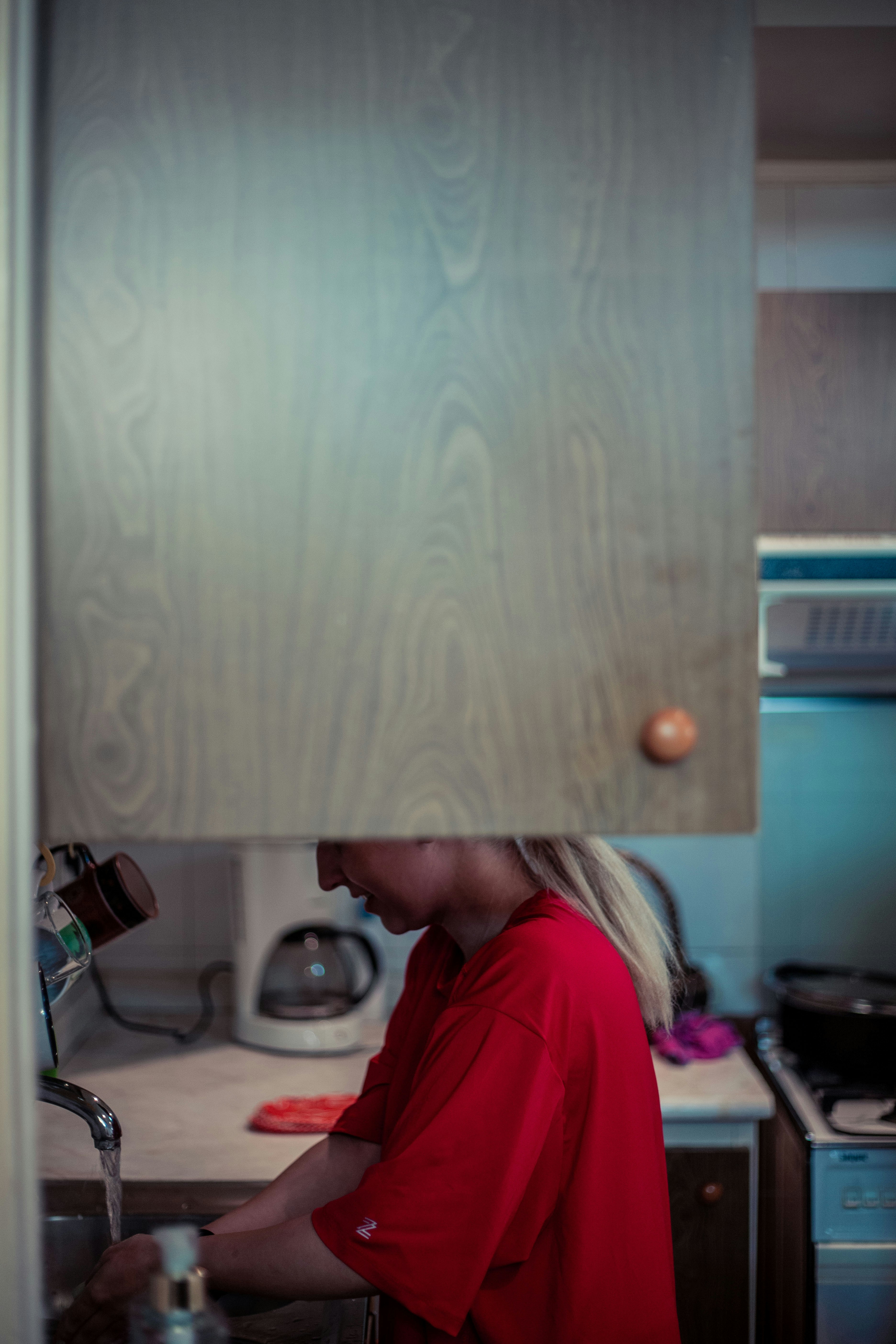 Woman washing hands at kitchen sink