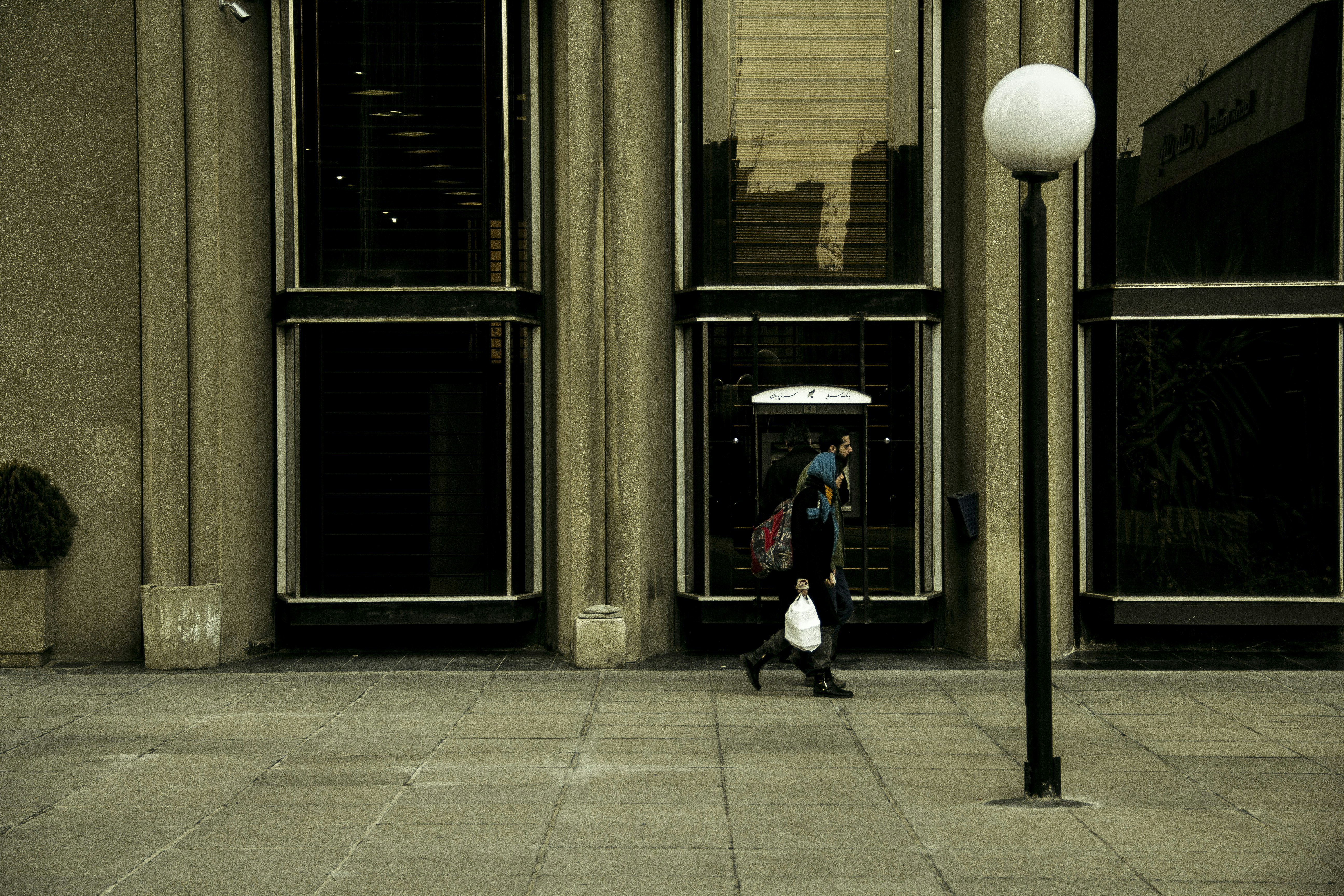 Person walks past a modern building entrance.