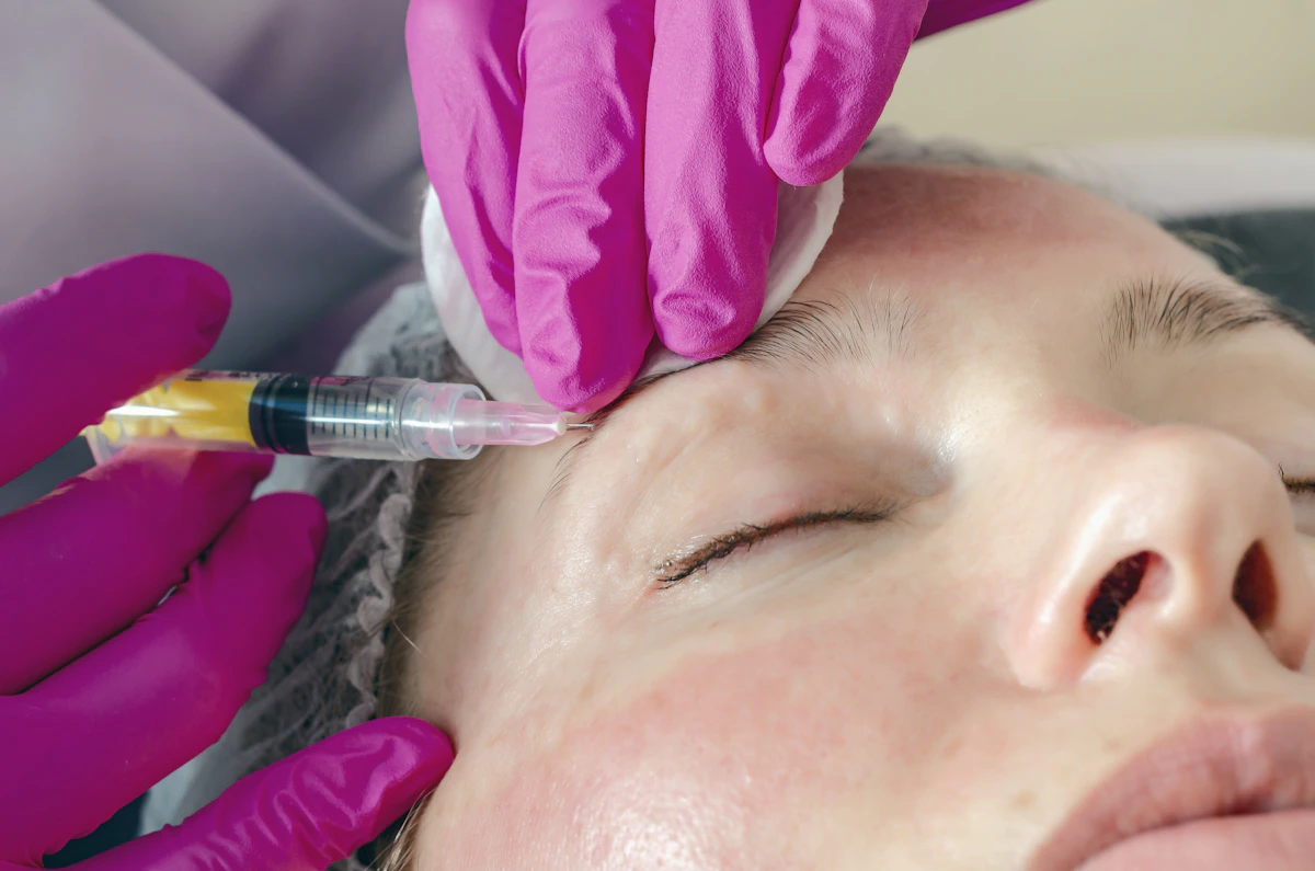 Person receiving a cosmetic injection in their forehead