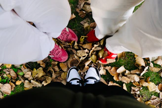 Four pairs of shoes on autumn leaves