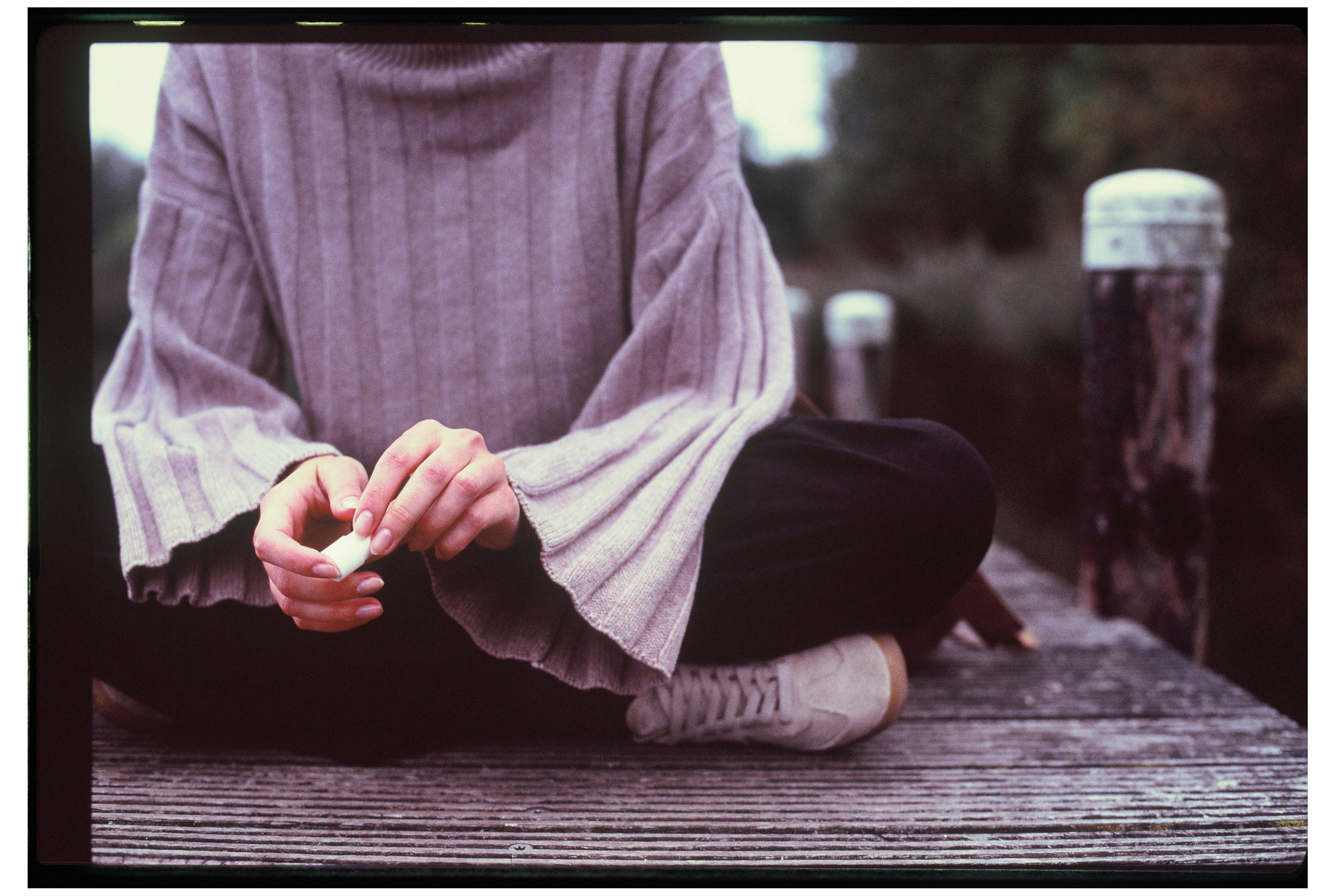 Akıllı telefonundan gelen yoğun sosyal medya bildirimleri arasında gözlerini kapatmış, huzurlu ve sakin bir şekilde derin nefes alan veya meditasyon yapan kişi.
