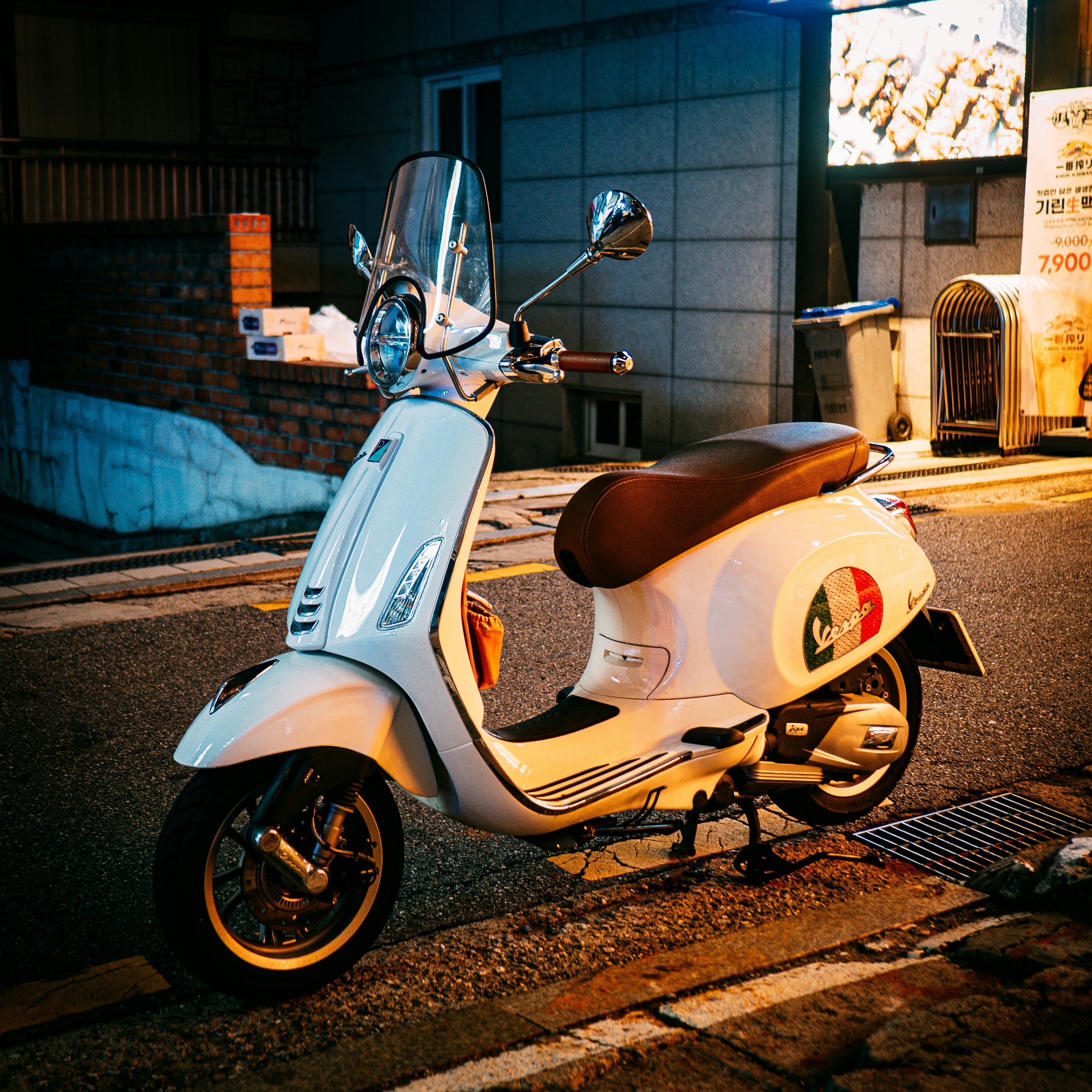 Weißer Roller, der nachts auf der Straße der Stadt geparkt ist