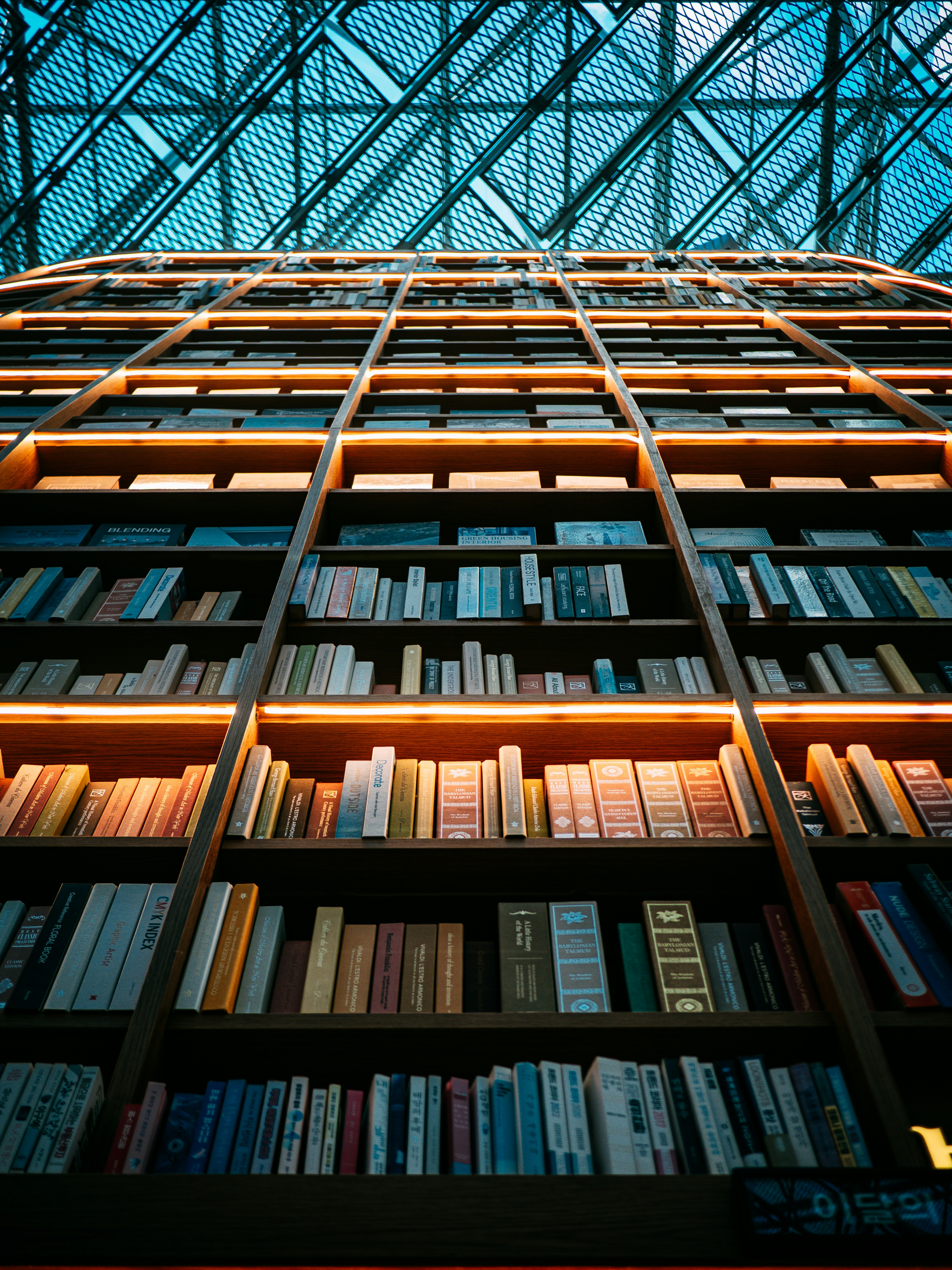 Hohe Bücherregale gefüllt mit Büchern, die von innen beleuchtet sind.