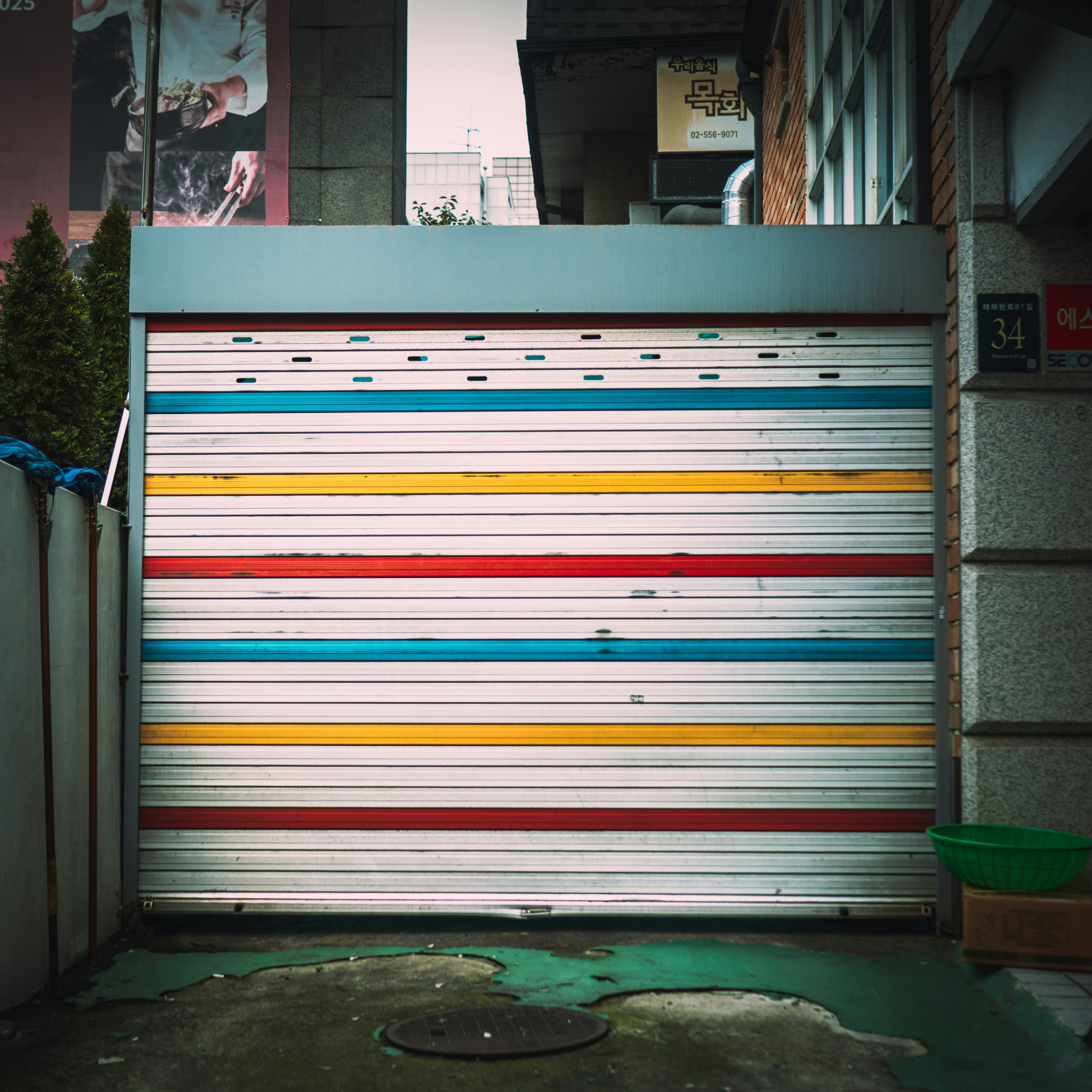 Geschlossenes Garagentor mit bunten horizontalen Streifen.