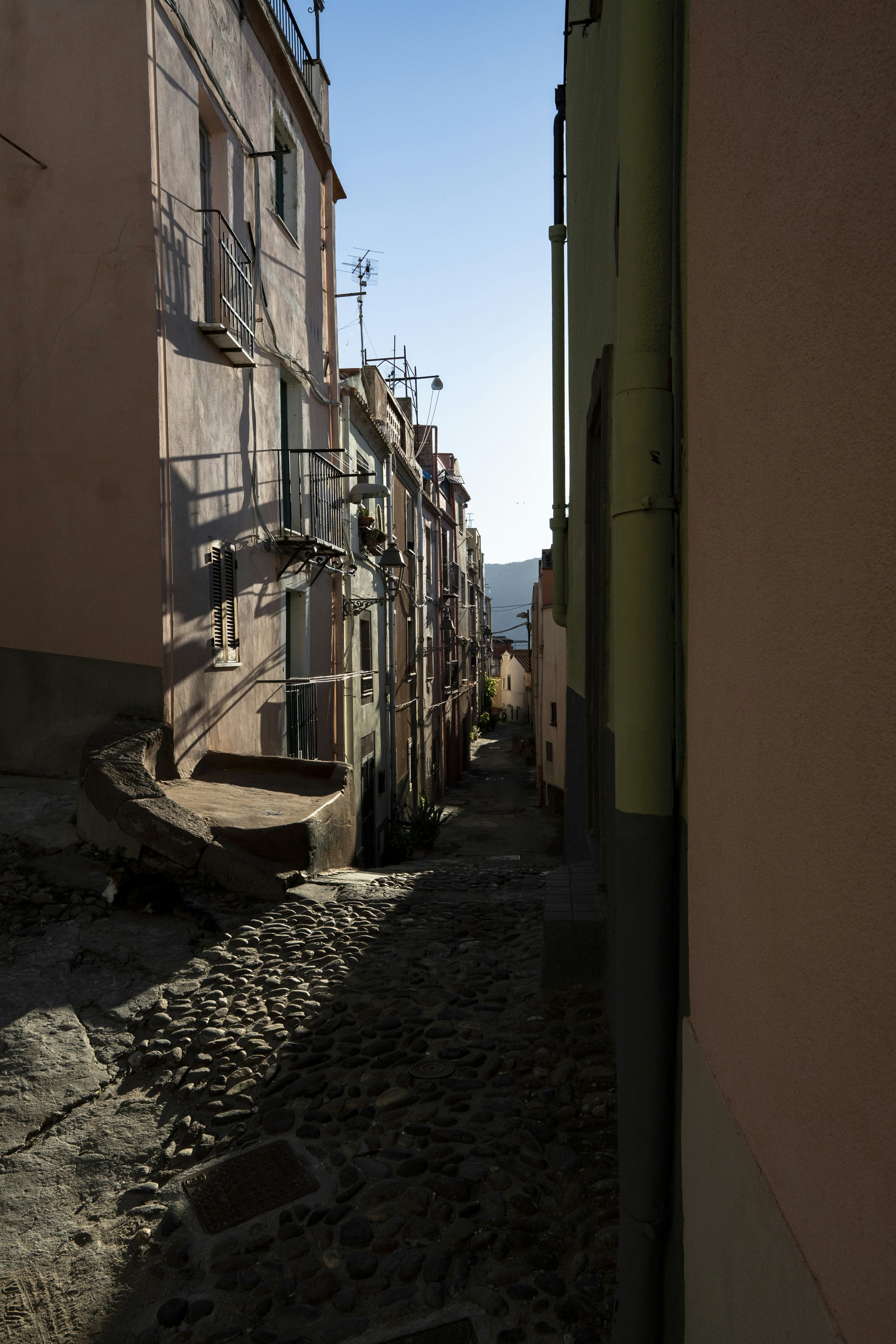 Narrow cobblestone alleyway between colorful buildings