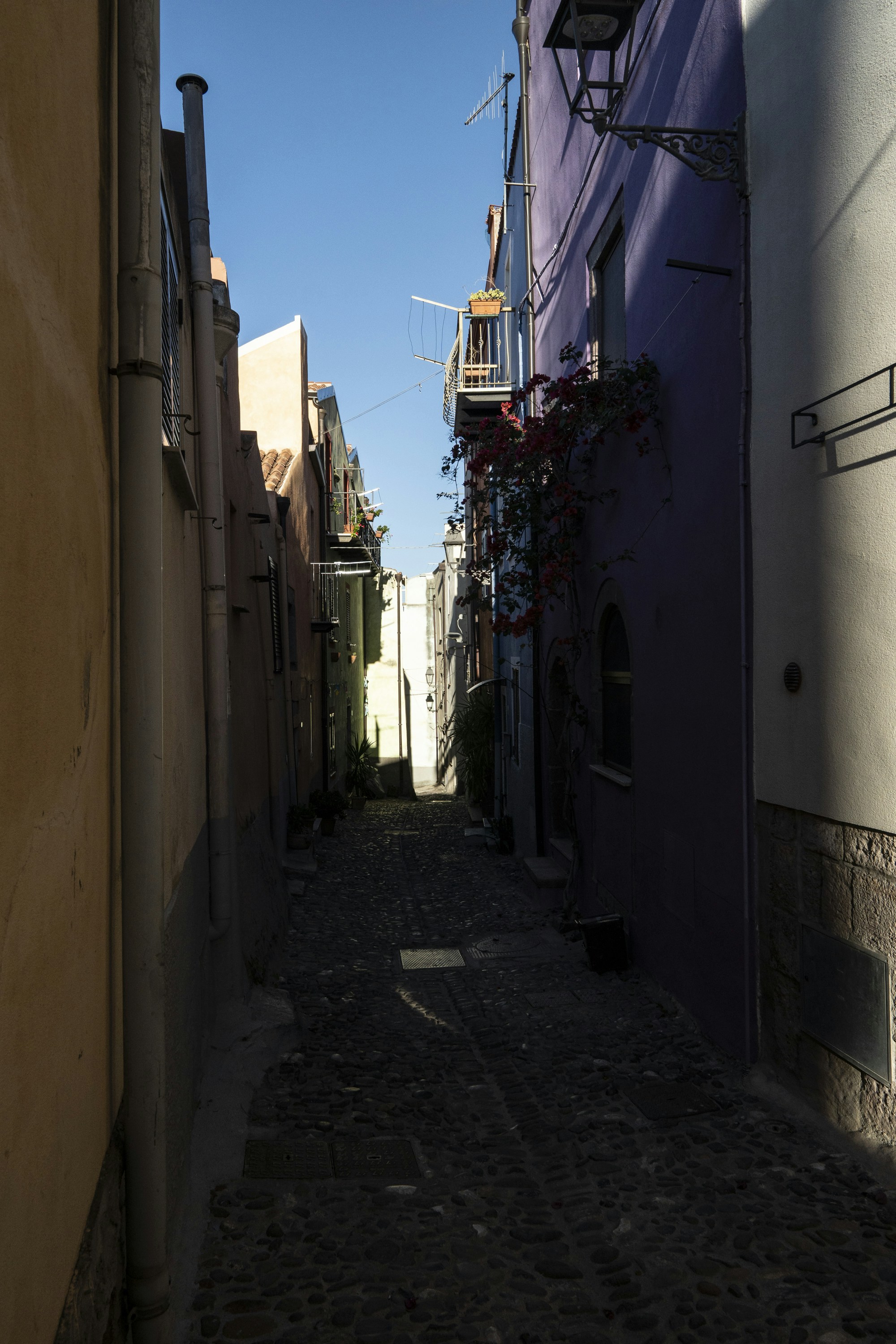 Narrow cobblestone alley between colorful buildings