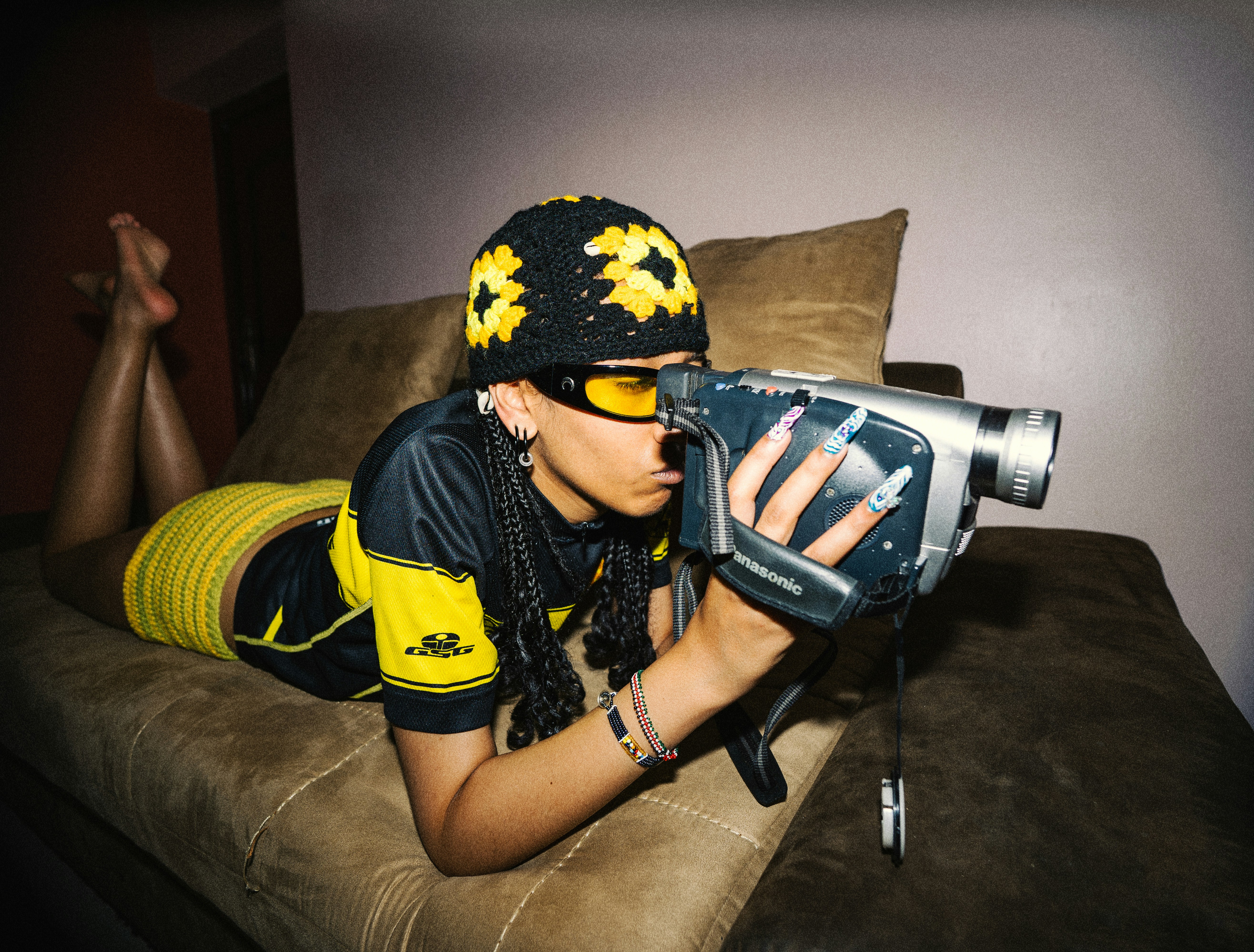 Wanita dalam film beanie dengan camcorder vintage
