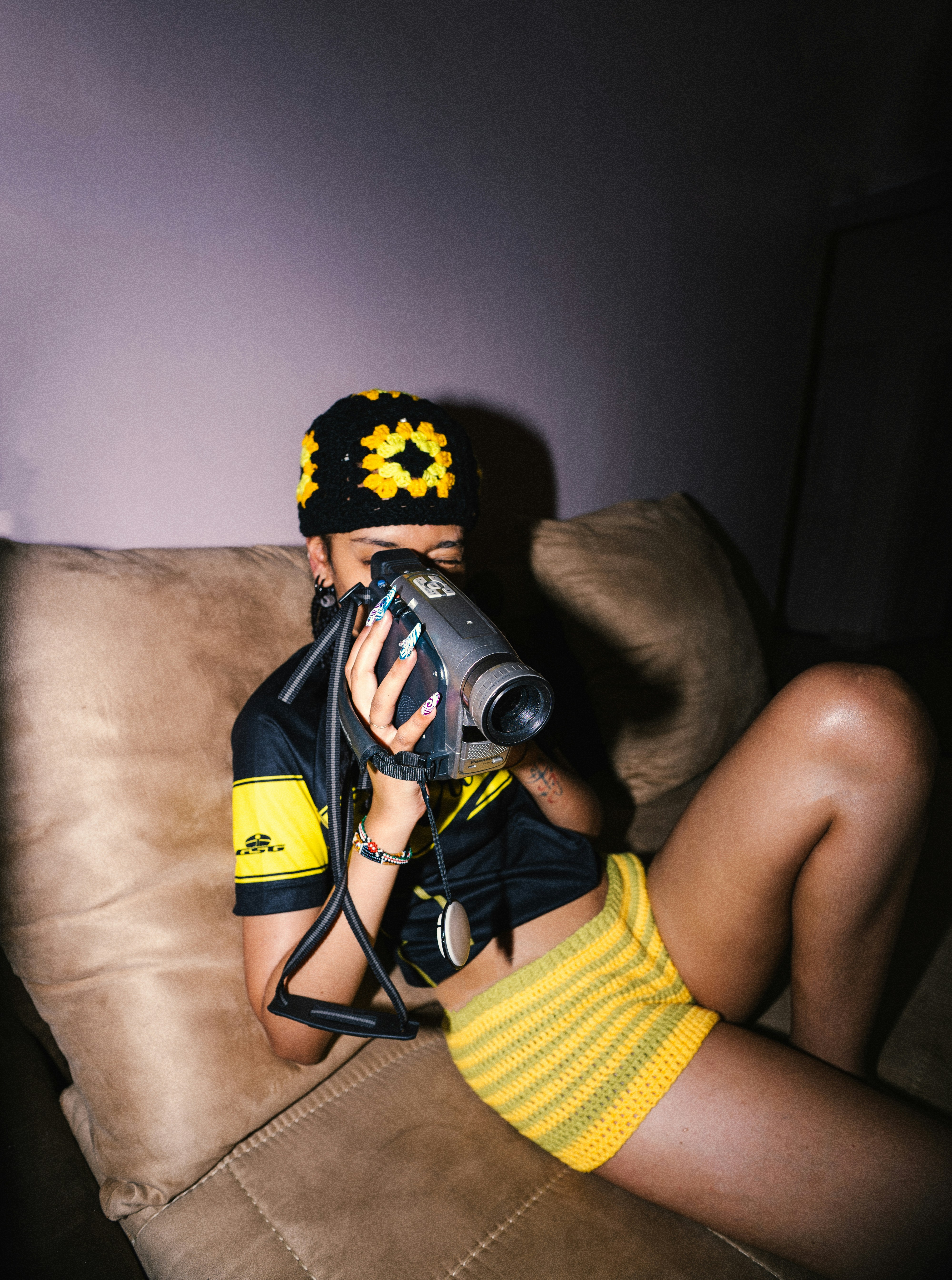 Woman in yellow and black holding vintage camera