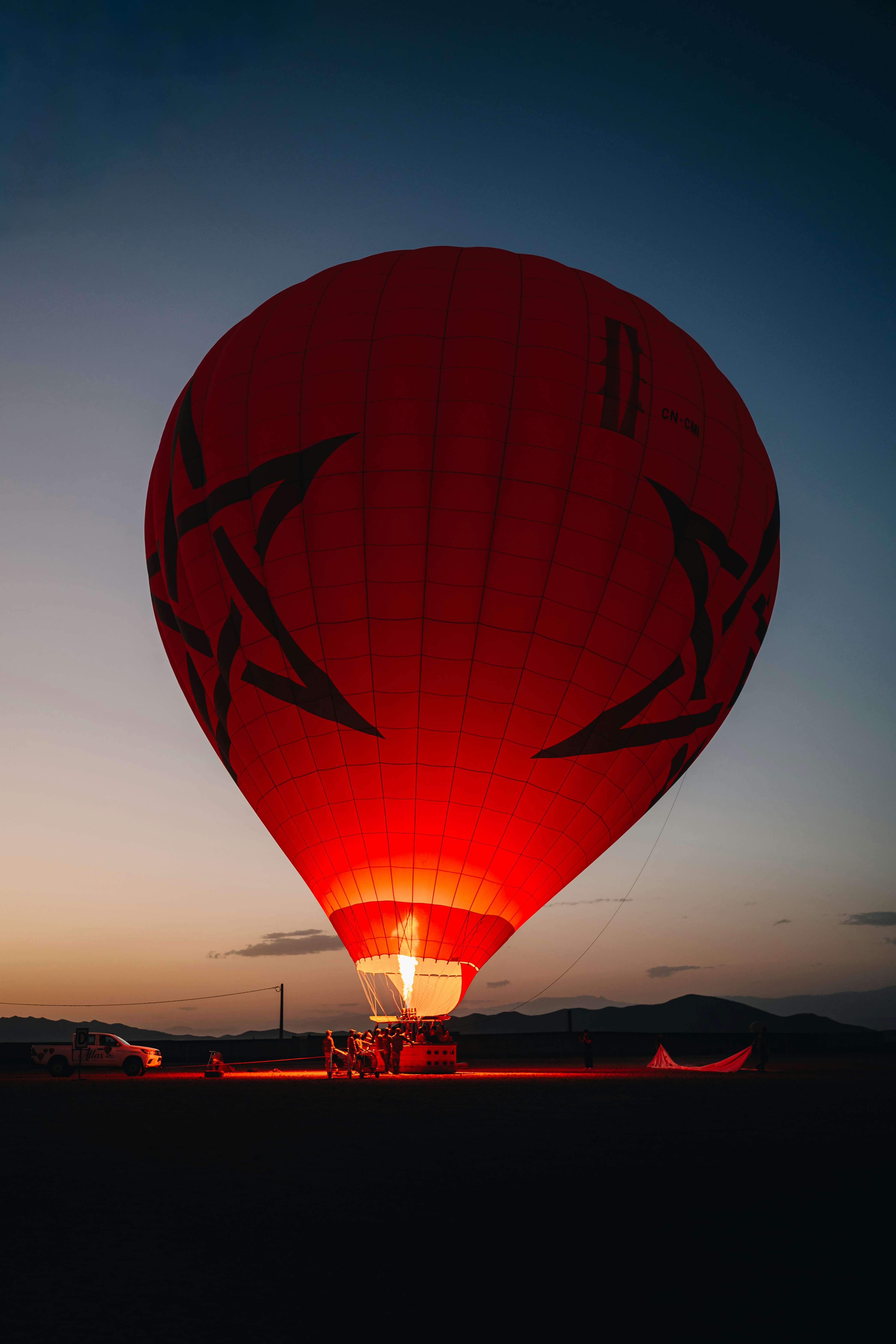 Red hot air balloon glows at dusk