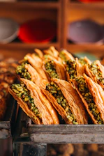 Golden baklava pastries filled with chopped pistachios