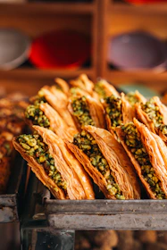 Golden baklava pastries filled with chopped pistachios
