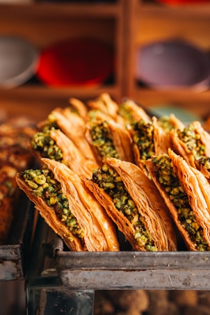 Golden baklava pastries filled with chopped pistachios