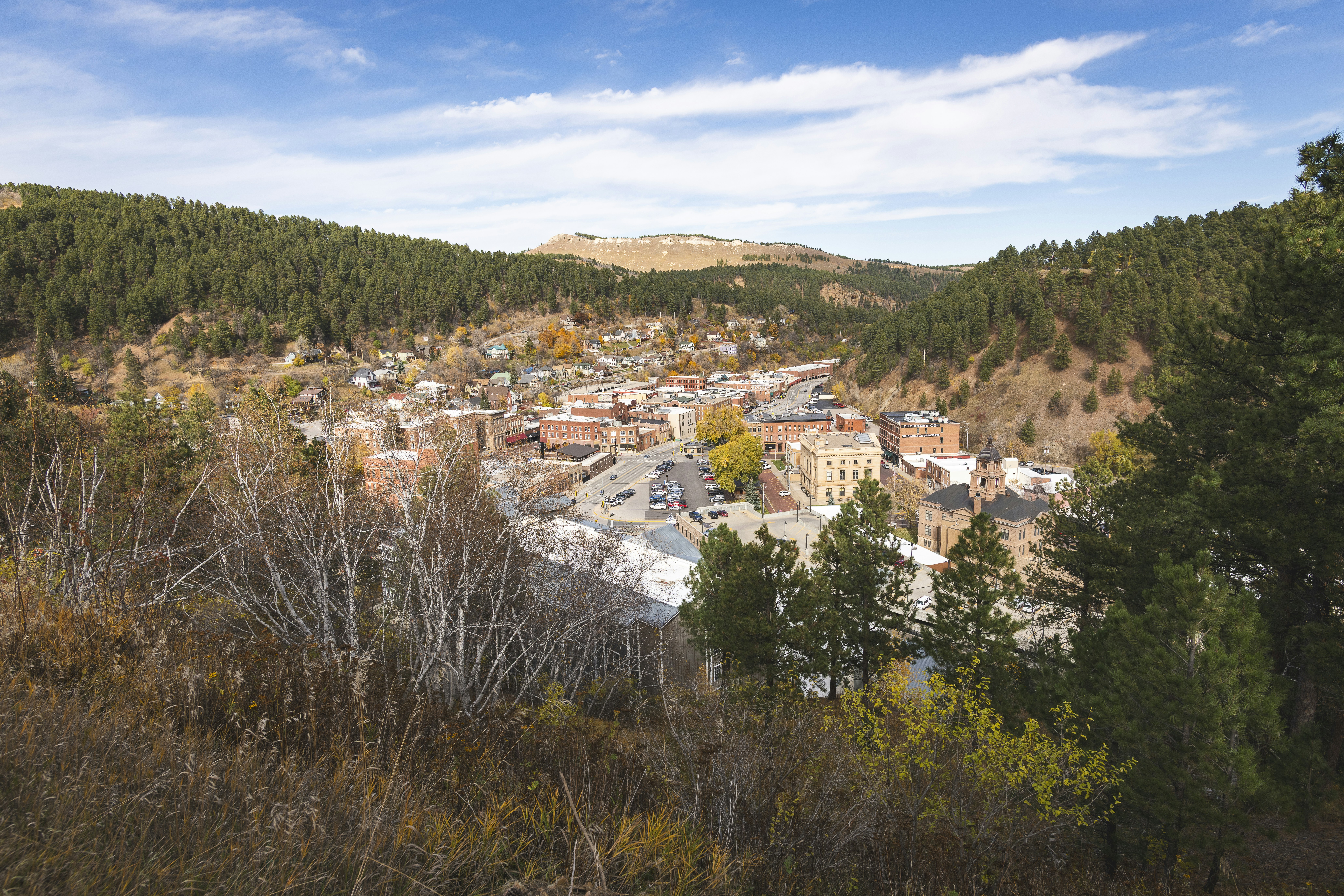 Historische Stadt, eingebettet in ein Tal mit Herbstbäumen.